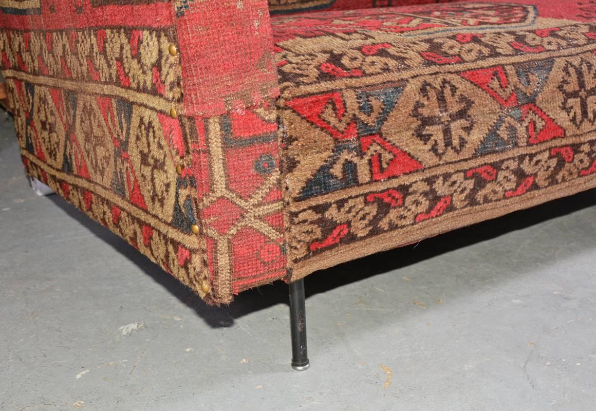 Mid-Century Modern Florence Knoll Style sofa, circa 1955, is recovered in antique Kilim carpet. A four-seat contemporary sofa is supported with original iron legs
Arm height 23