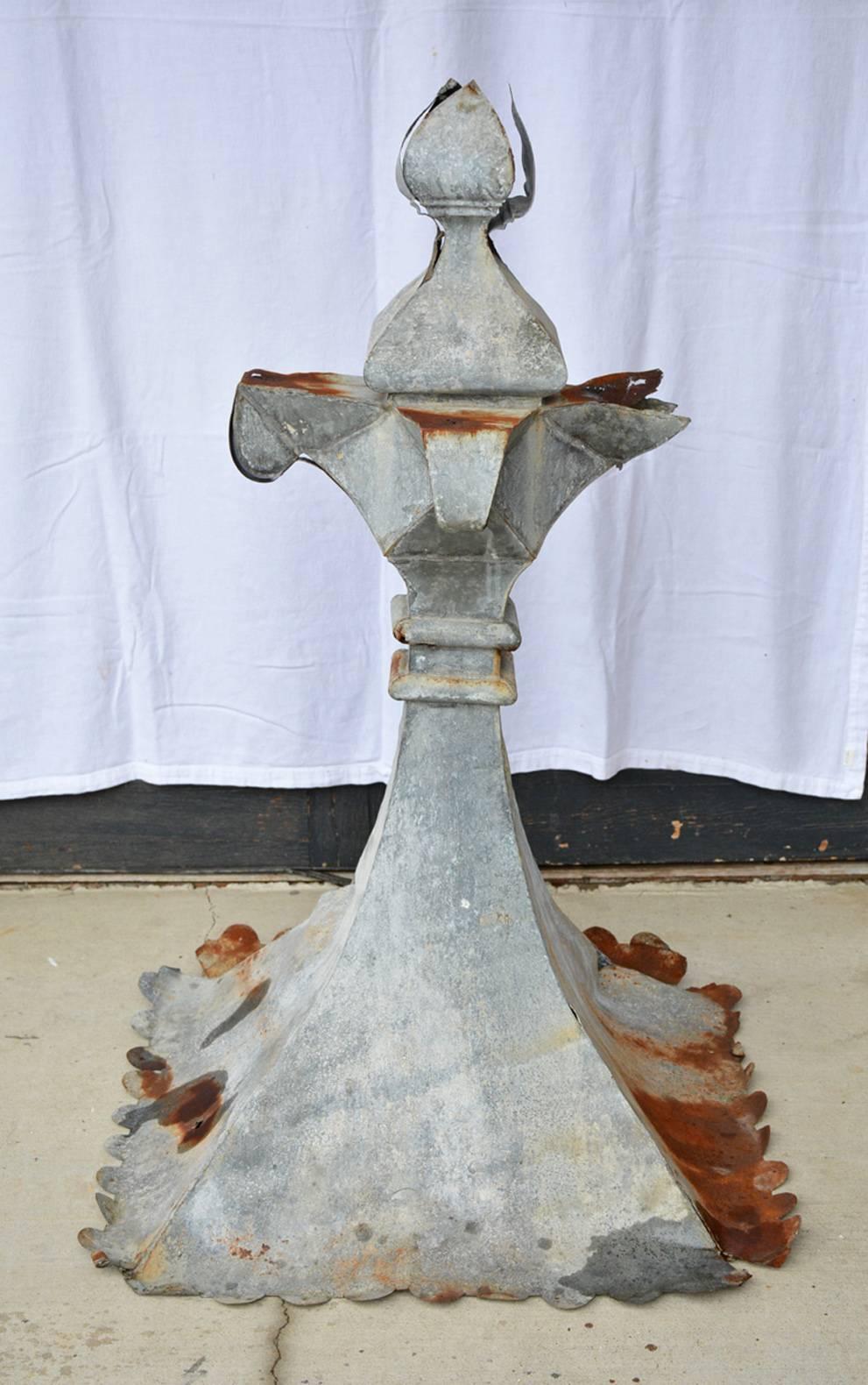The antique zinc finial has small scallops around the bottom with holes for nails or screws when attaching to a building.
