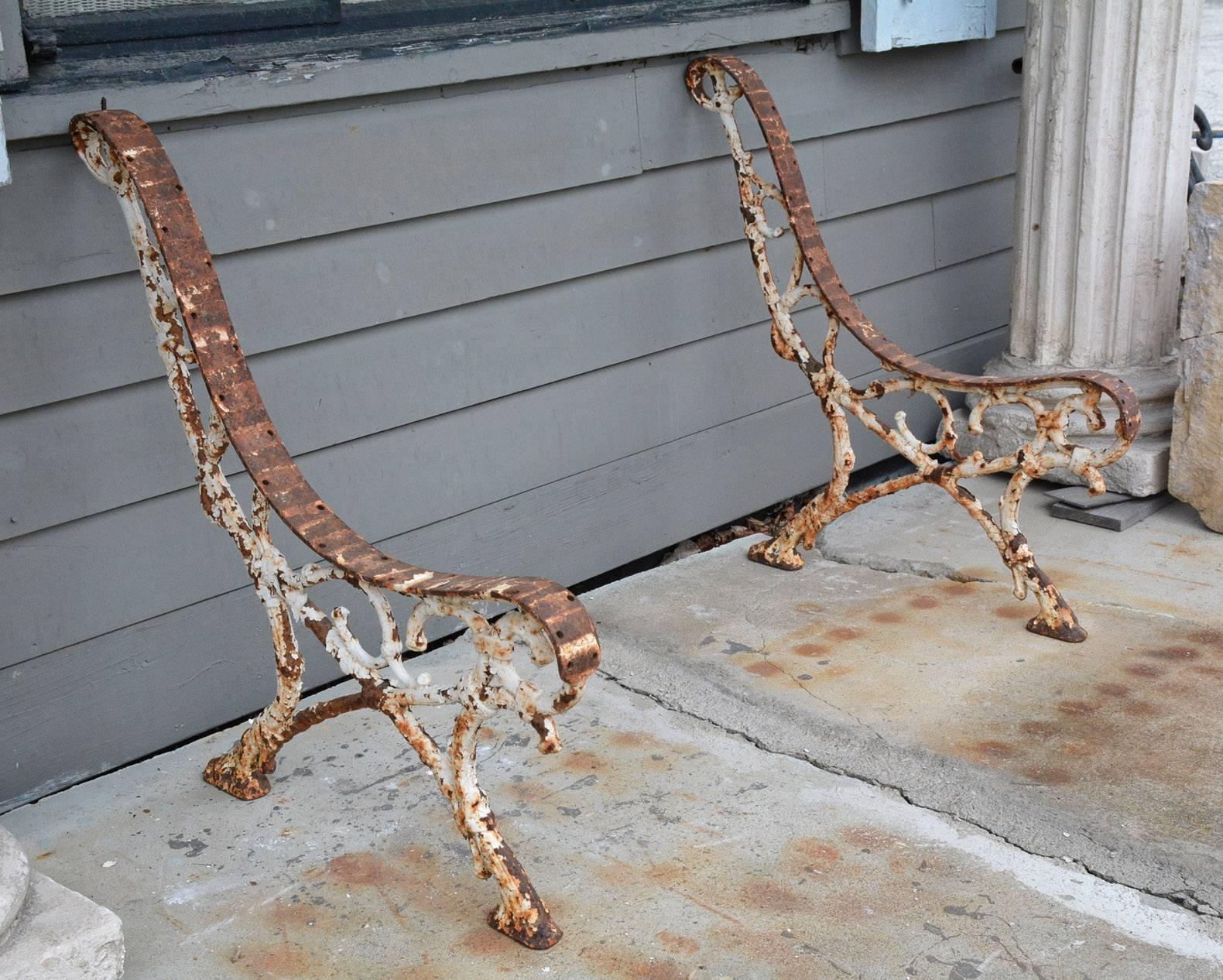 Pair of Egyptian Revival cast iron garden bench braces with legs that will support spaced and narrow wood boards for seating and back. There are screw holes for attaching the boards. The supports have original rusted paint.

Slats can be installed