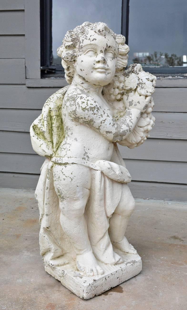 The Victorian cast stone garden statue is leaning against a tree stump holding a bunch of grapes. A cloth is decorously draped around him. The putti has been painted white.


Base: 9.50