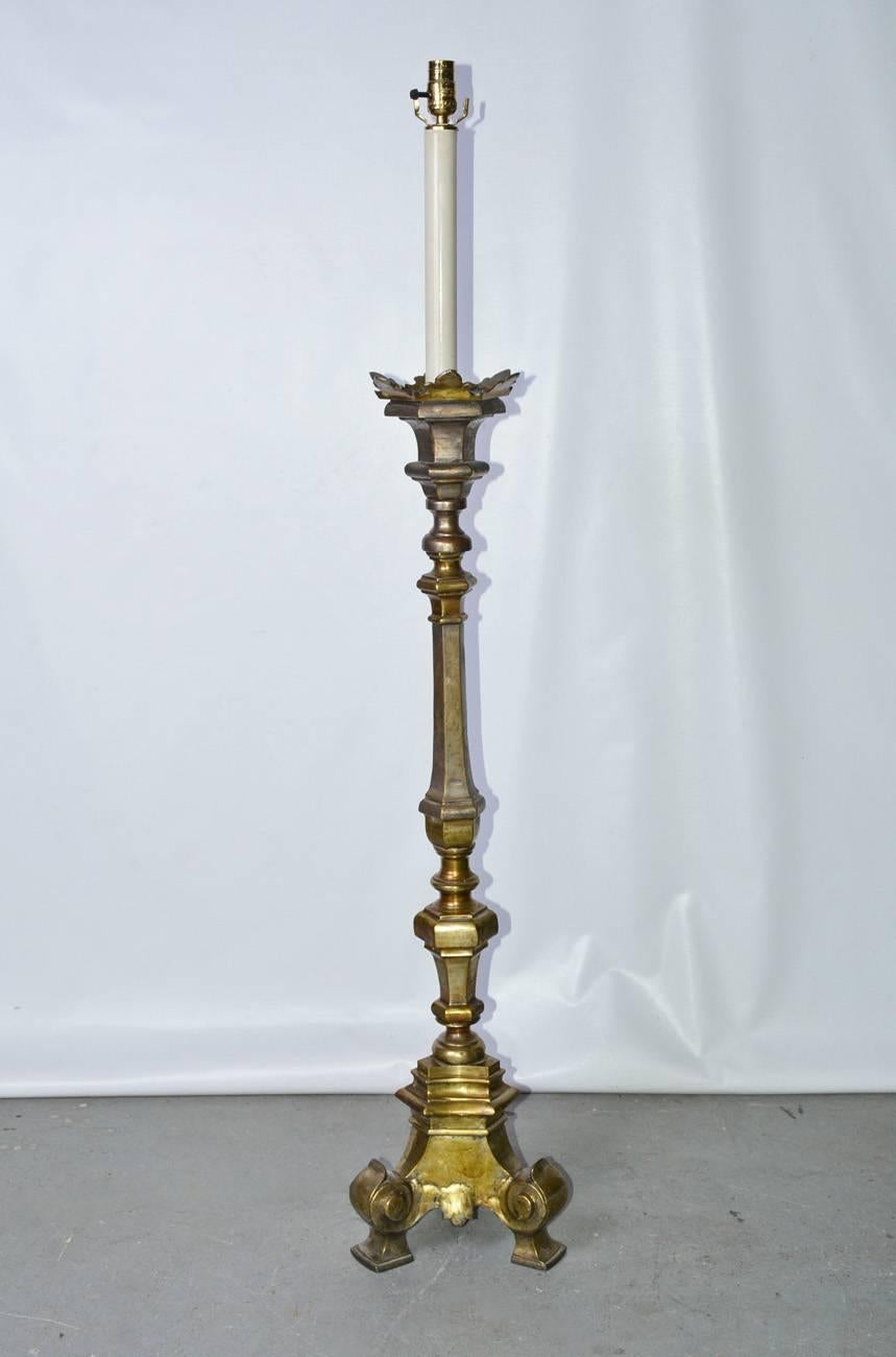 The antique solid brass floor lamp originally an alter candlestick in the Renaissance style that has been converted to a floor lamp. 
Lamp shade for photography purposes only, price does not include shade.
It has been electrically rewired for US