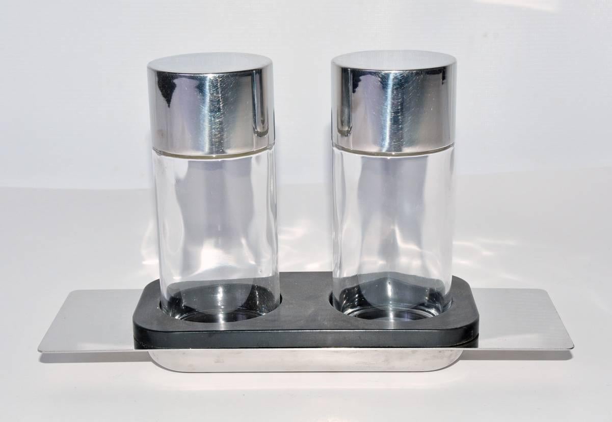 A masterfully designed modernist oil and vinegar cruet set of impeccable quality made of glass and polished metal by Cini & Nils, Italy, 1970s. 5.75" high. In great condition with some minor wear.

Measures: Bottle, diameter 2", height