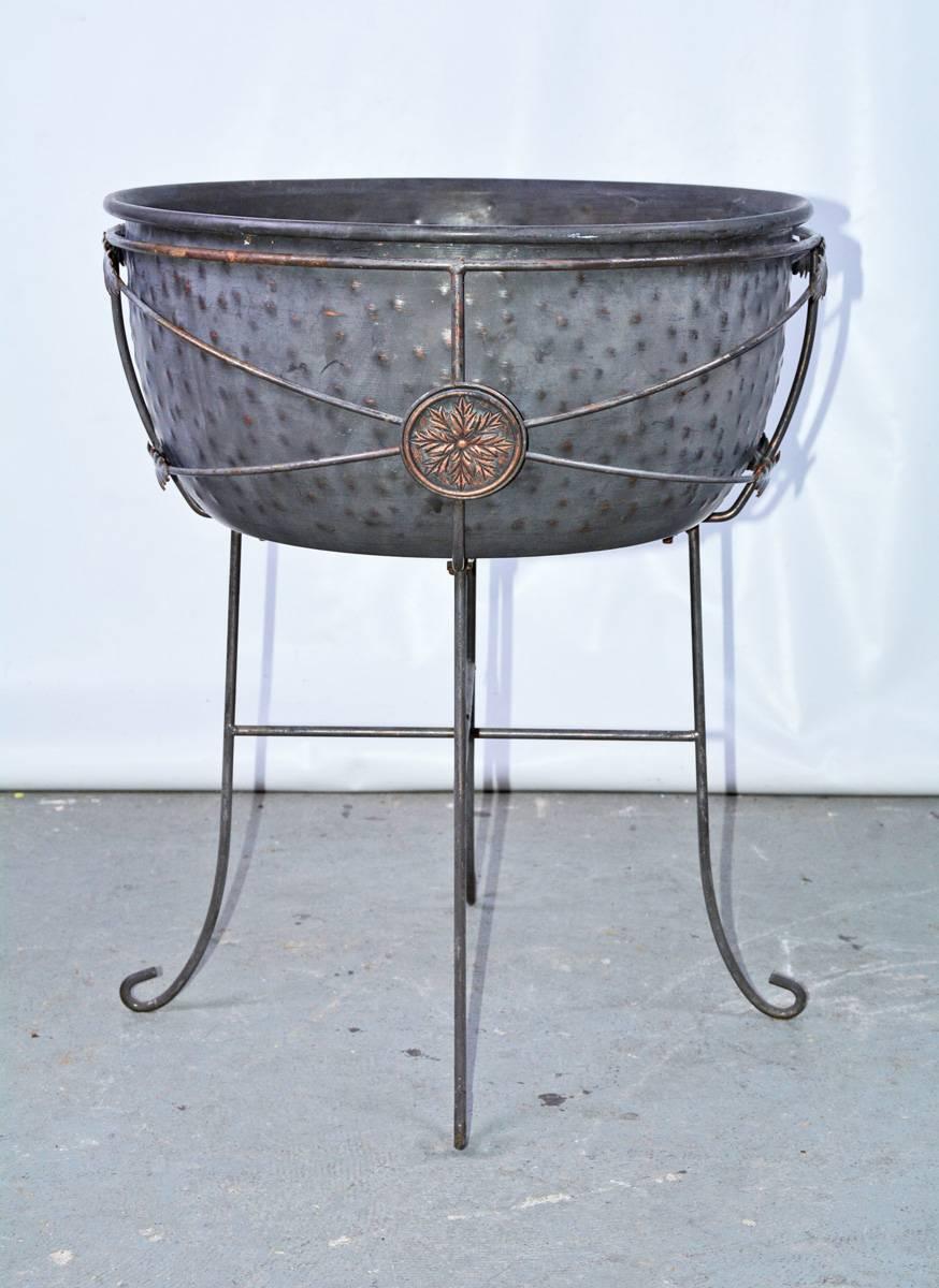 Iron planter or jardinières on stand with four c scroll feet and leaf shaped metal detail with leaf style medallion detail. Measures: approximate 25 inches tall 18 inches diameter.
Height of bowl 8.25