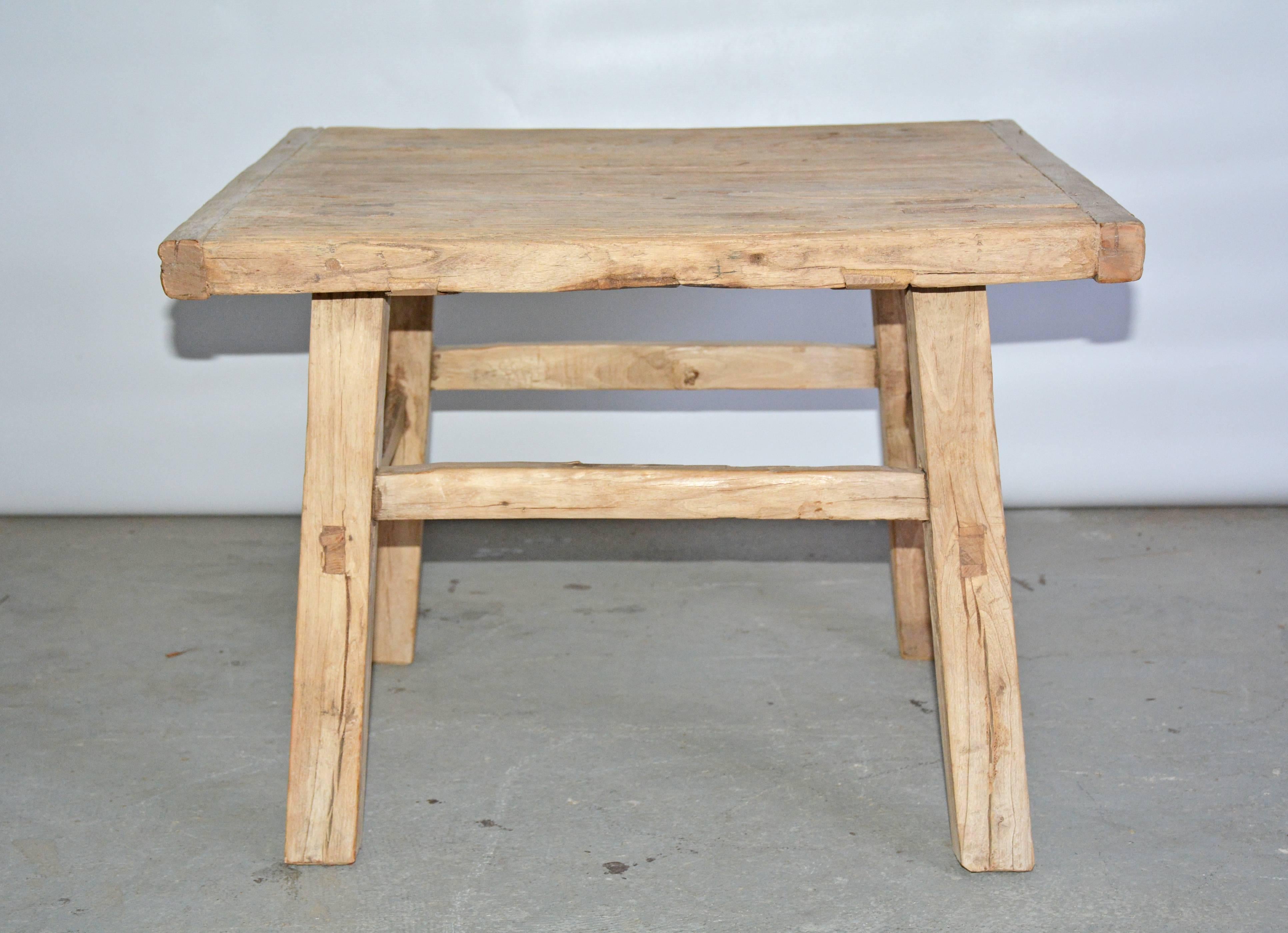 The rustic Swedish country style coffee table or end table in natural teak wood has bread board ends, splayed legs and stretchers for stability.