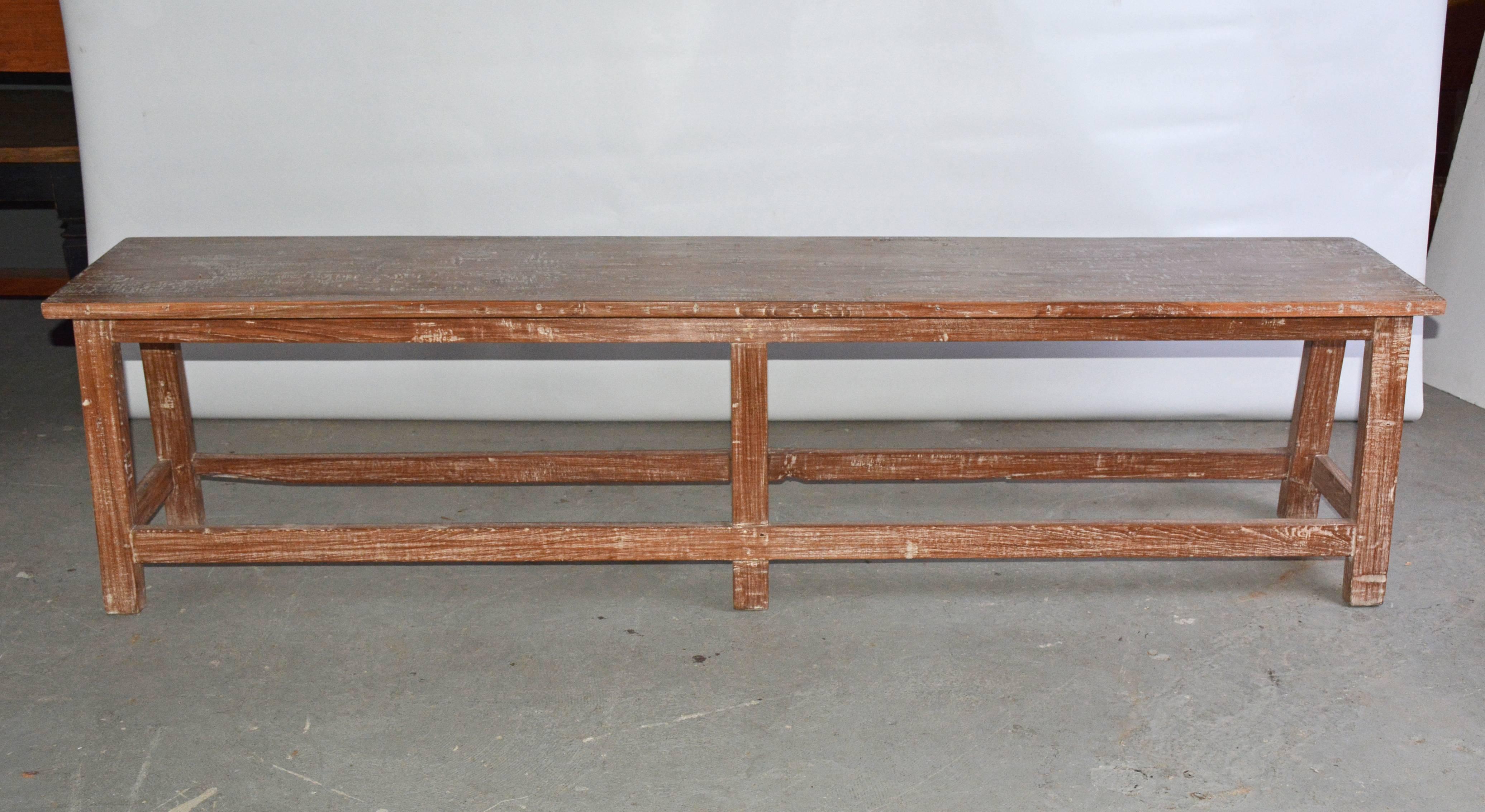 The rustic teak piece is at the right height to be used as a bench or coffee table. Stretchers secure the six legs. Perfect for dining table seating or use as garden or patio furniture.
 