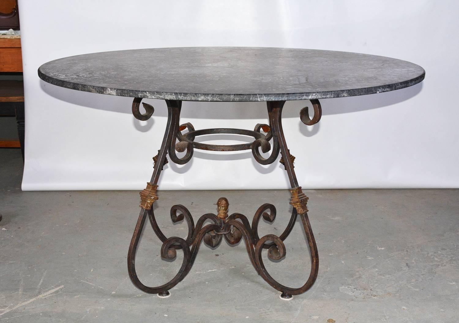 The round indoor or outdoor metal base garden dining table marries a French continental baroque style wrought iron base with brass decorations and a contemporary black marble top. Top and base can be sold separately. Base: $2900.00.