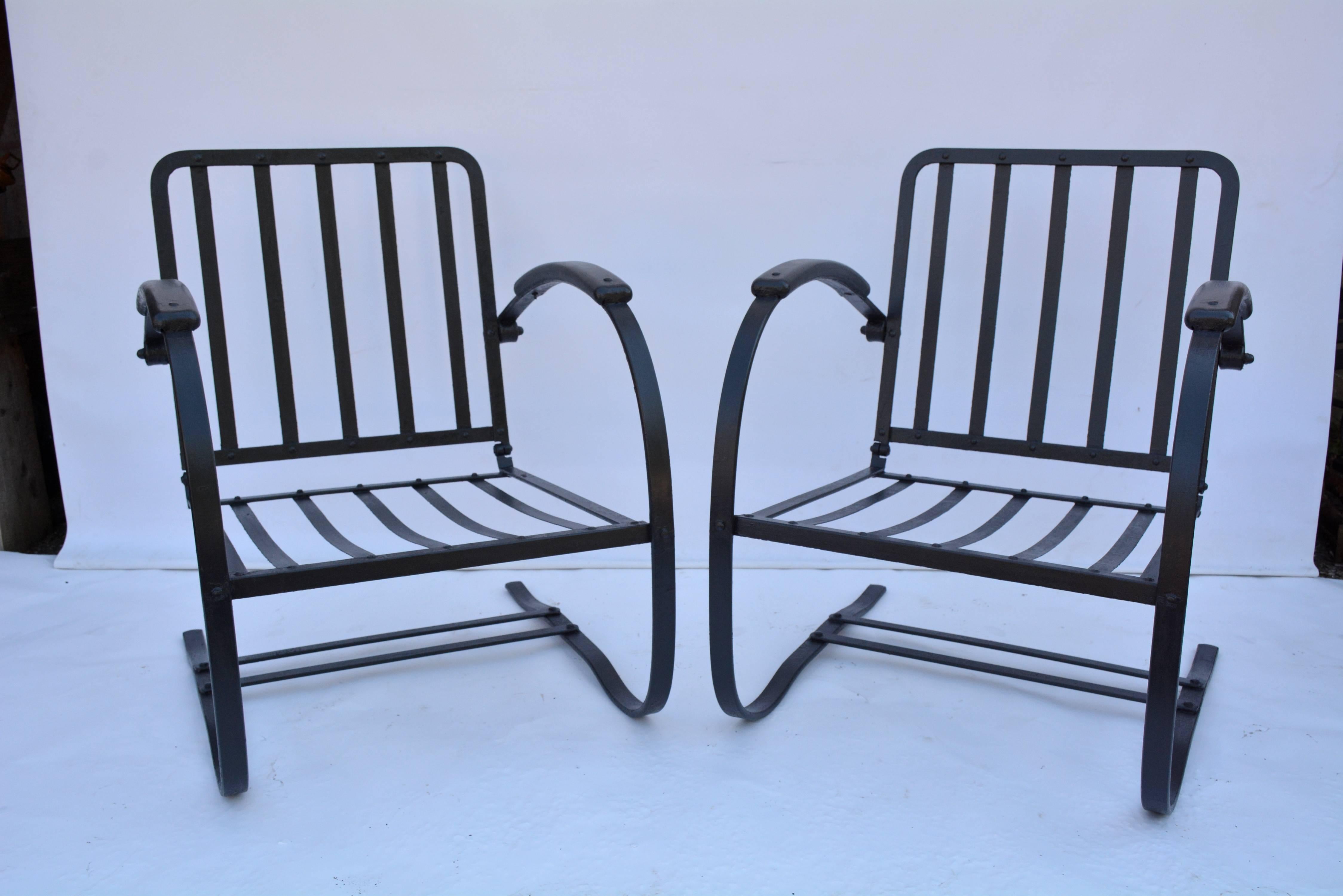 Comfortable and inviting black metal garden or porch arm chairs have a spring action for added comfort. The arms are 