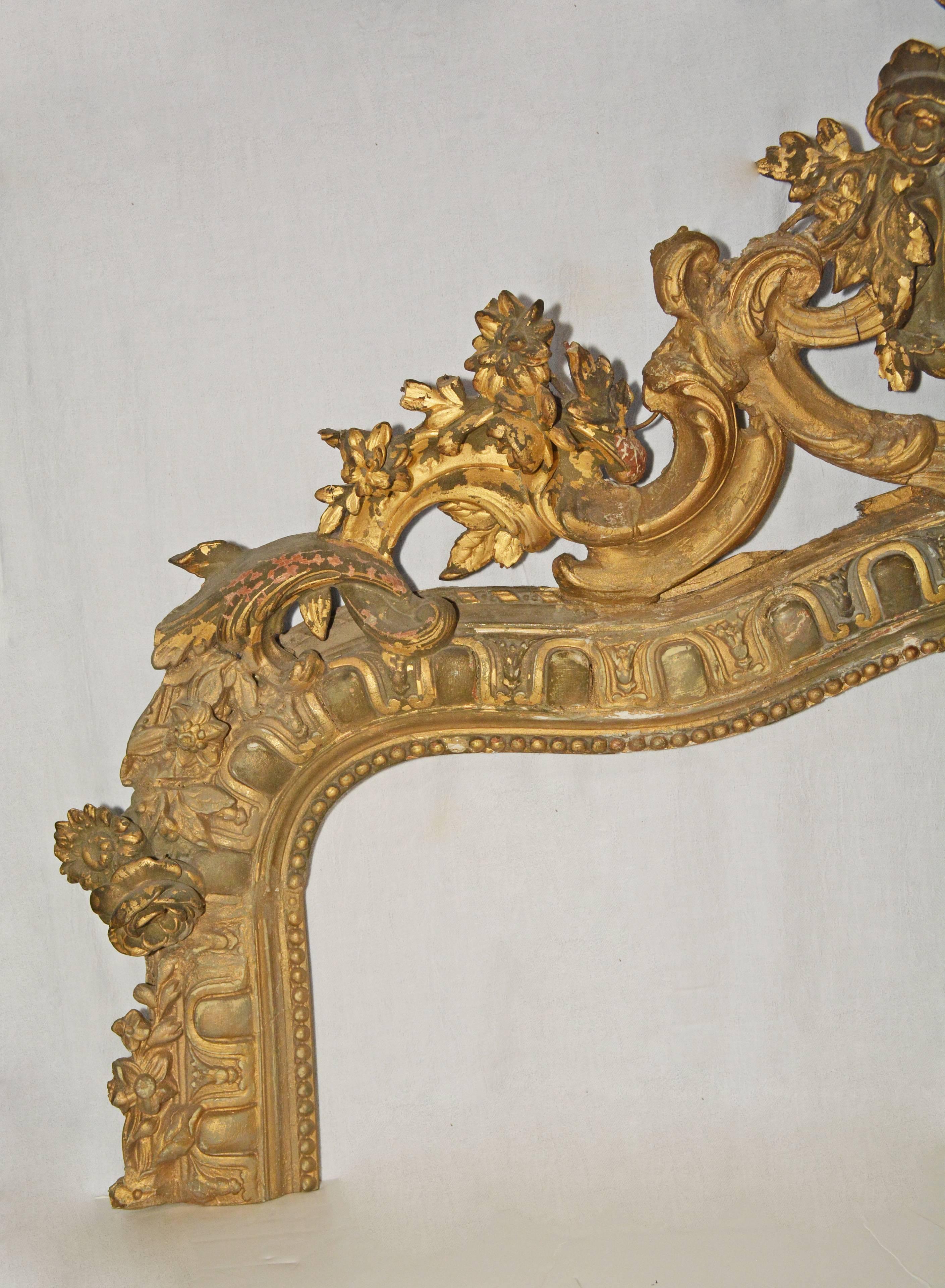 La partie supérieure du cadre du miroir en bois doré de style rococo victorien est sculptée à la main de fleurs, de feuilles et de volutes. L'ovale central contient deux oiseaux aux ailes déployées, un nid et des œufs. Il y a également une rangée