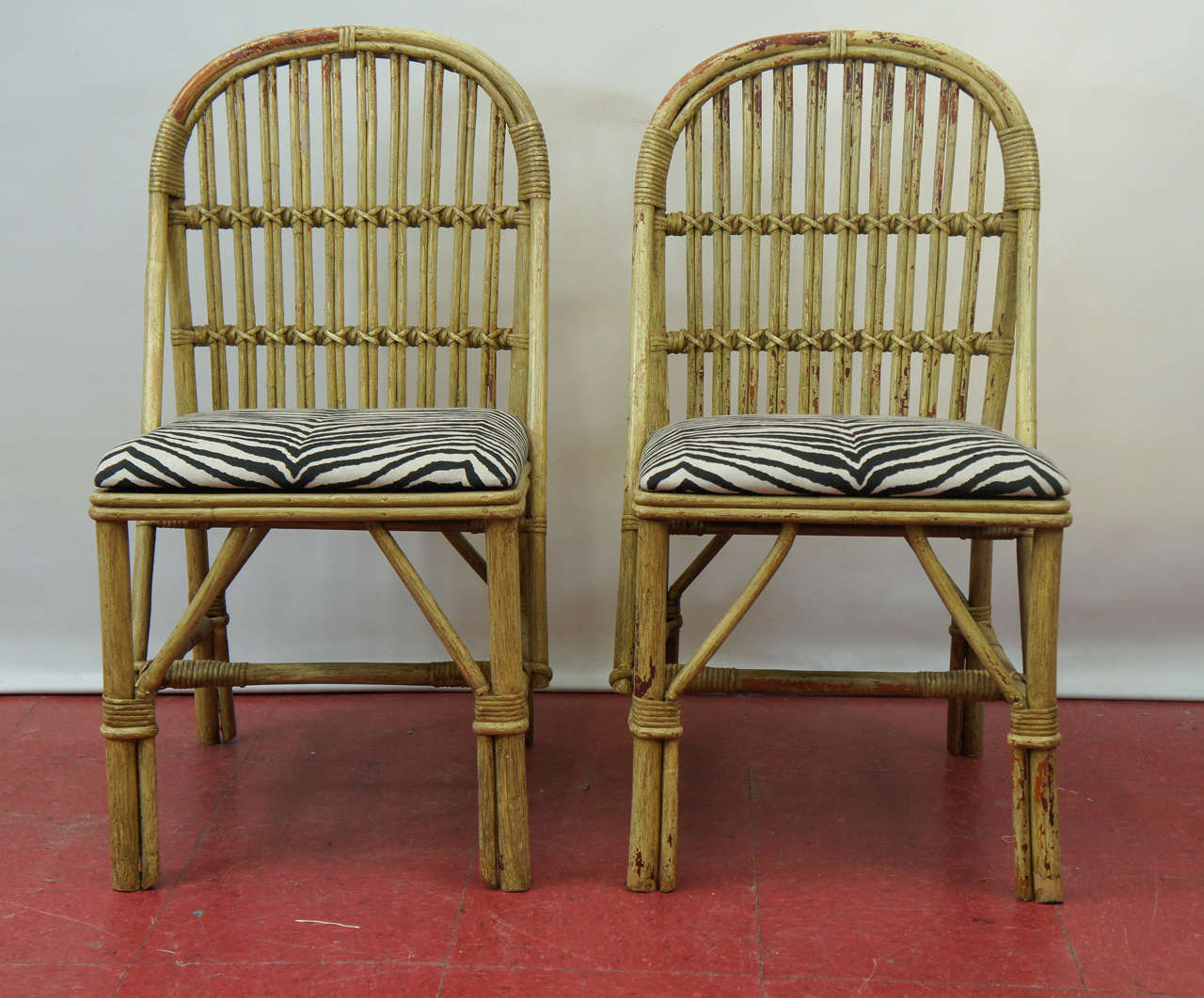 A wonderful stylish pair of painted bamboo side chairs. Seat cushions covered in cotton zebra fabric. Paint has been mostly worn off leaving wonderful patina combining the rustic and elegant feel at the same time.

 