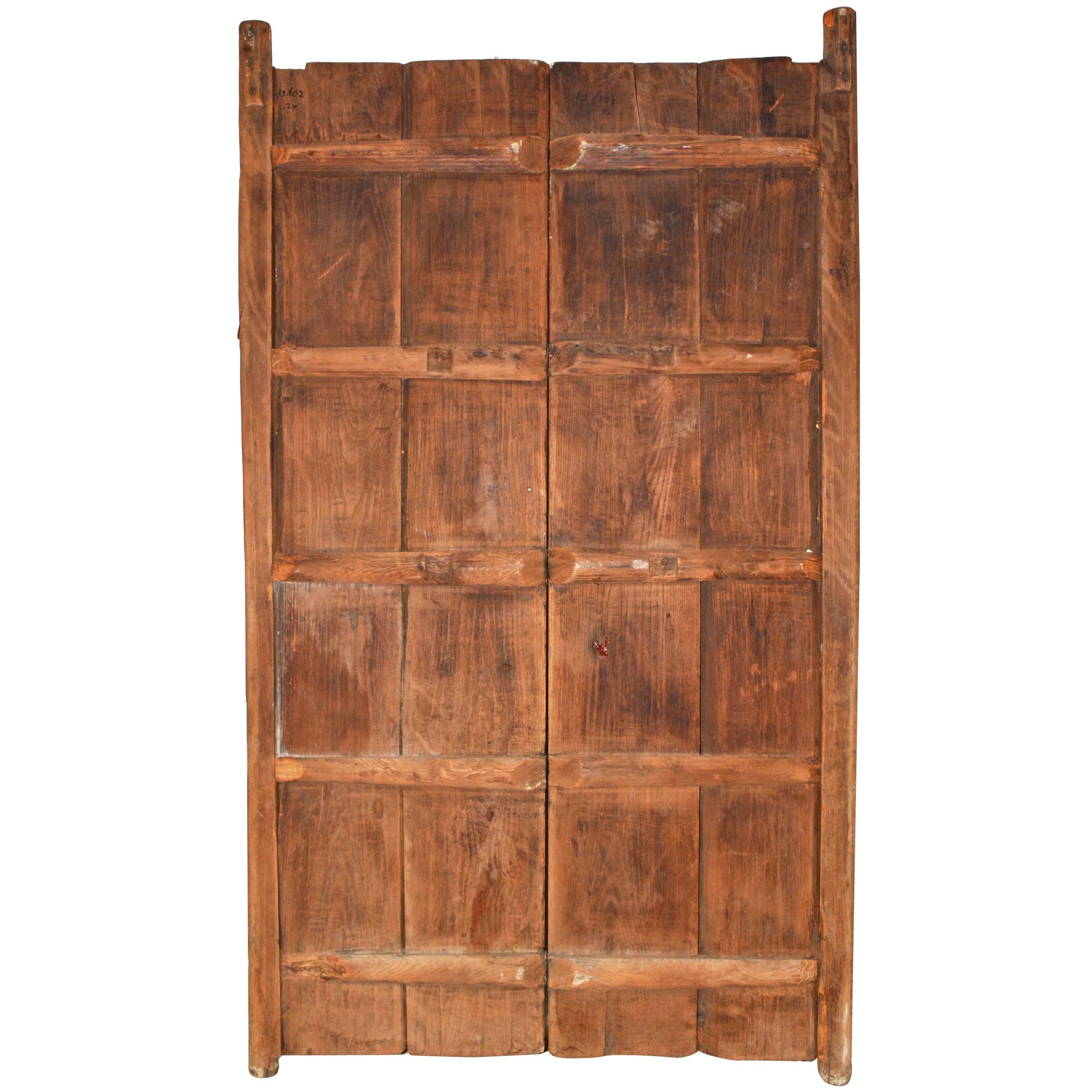 The pair of Medieval-style wood doors are held together with horizontal wood strips on the backs. Pegs at the tops and bottoms are made for swinging the doors open and closed.

Pegs at top: 2.50