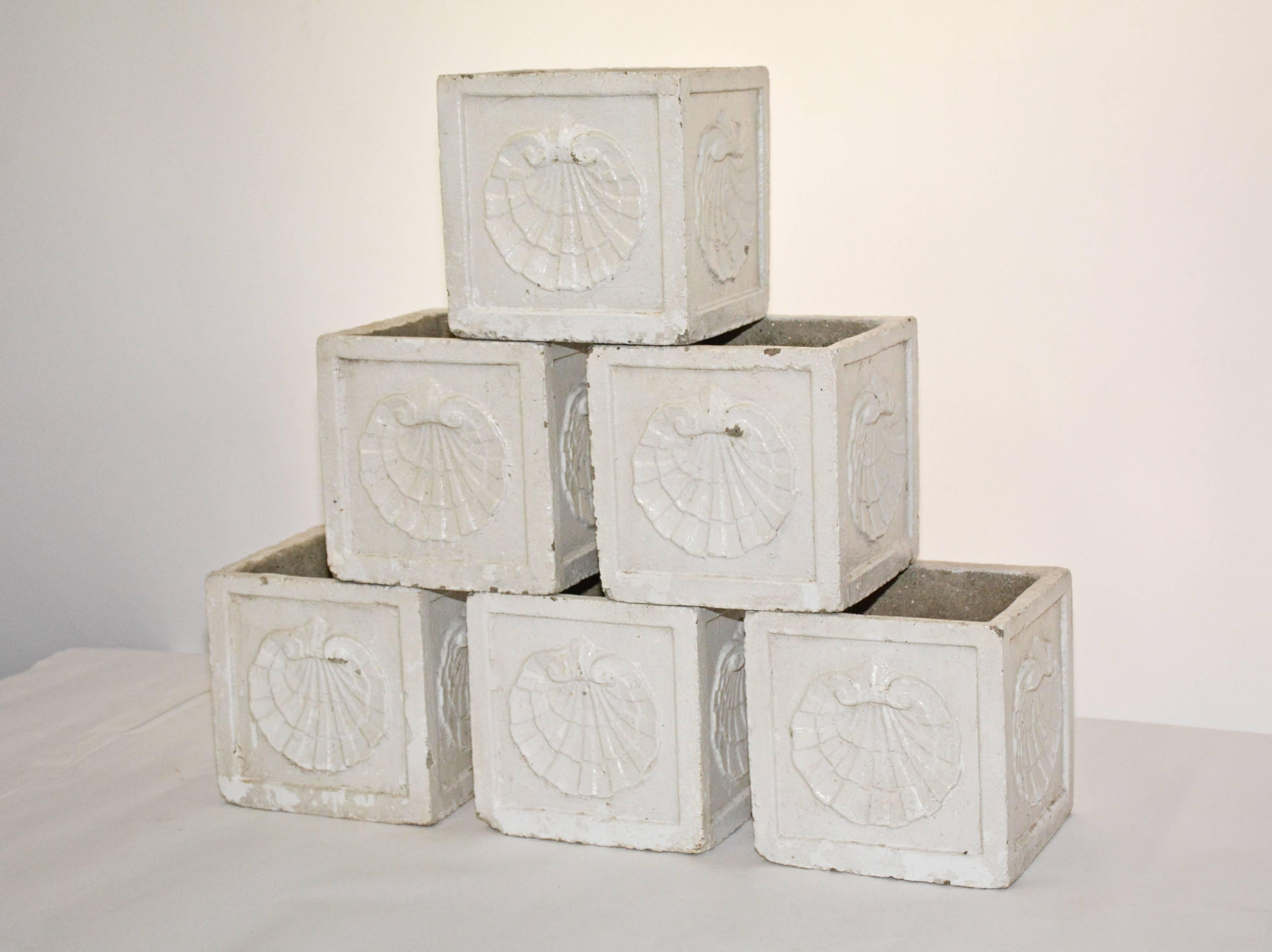 The six vintage planters are made of cast cement with white ceramic glaze decorated on all four sides with sea shells en relief. Single holes in the bottom are for drainage. Priced per piece.
 