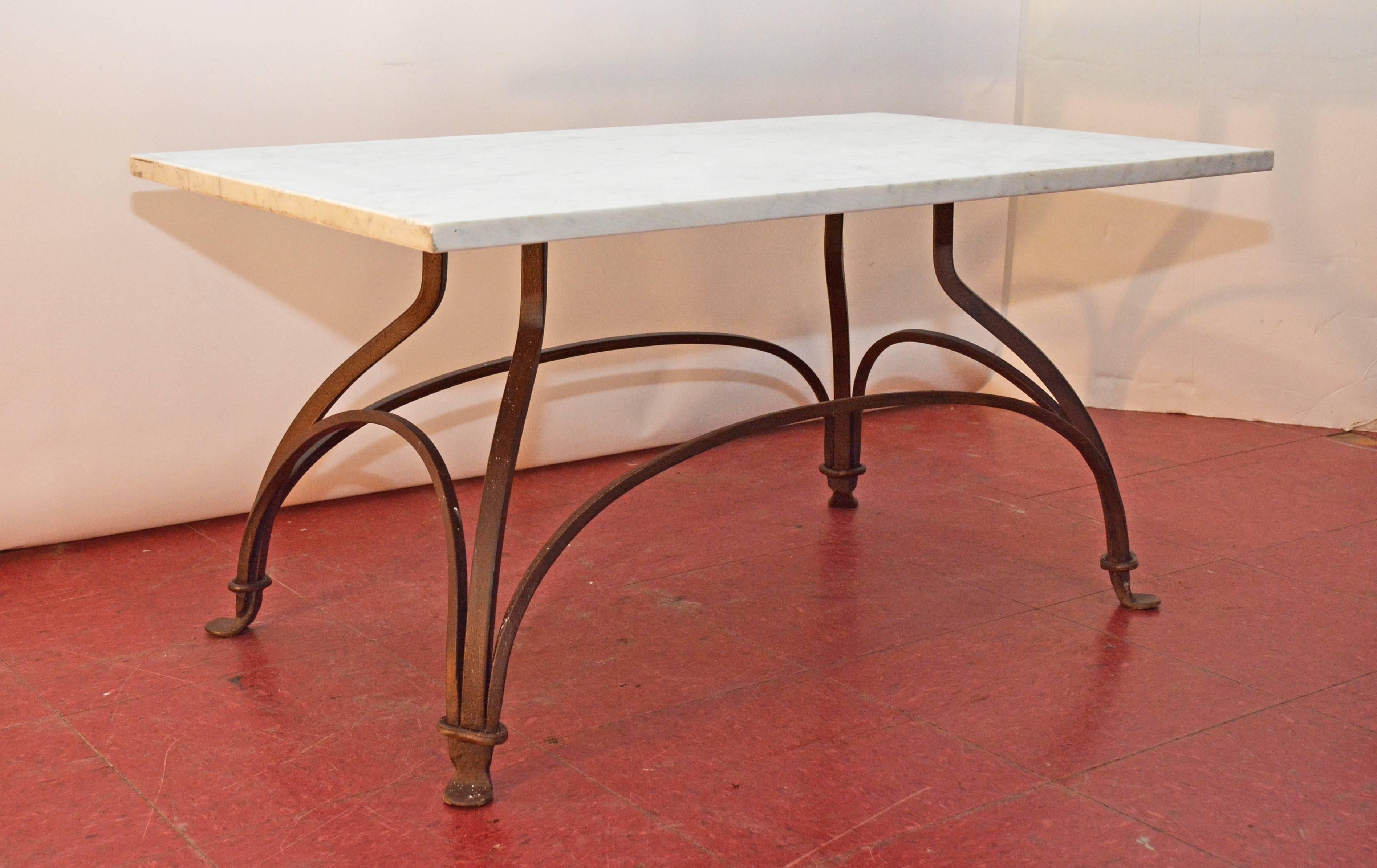 Indoor or outdoor metal base garden coffee table with grey-veined white marble top married to a bronze or black wrought iron base that is secured by gracefully arched stretchers and ended at the bottom by padded feet. Top and base can be sold