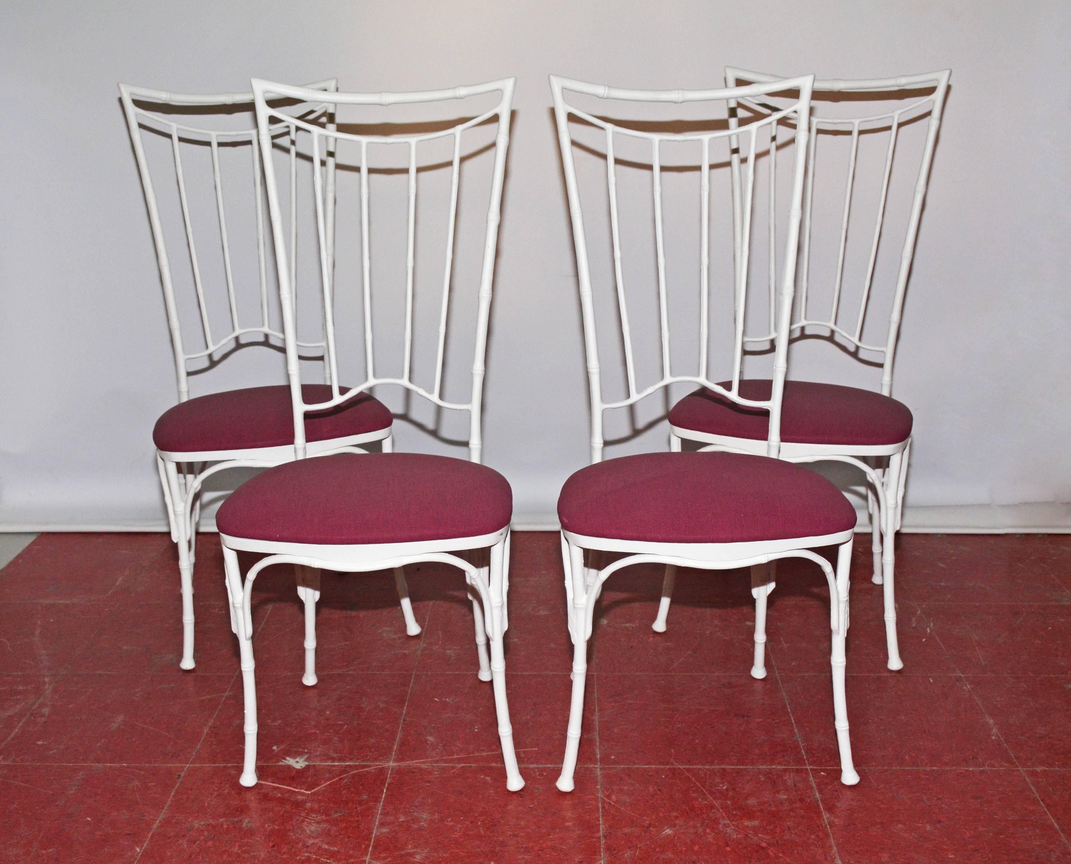 The chinoiserie style faux bamboo dining chairs are made of wrought iron painted white and have seats upholstered in purple outdoor fabric. The set is suitable for indoor or outdoor use. Seats can be easily recovered with a fabric of your choice.