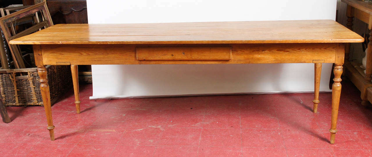 Beautifully proportioned, this country farm harvest table has turned legs and a divided centre drawer with tongue-and-groove construction. Apron measures 6