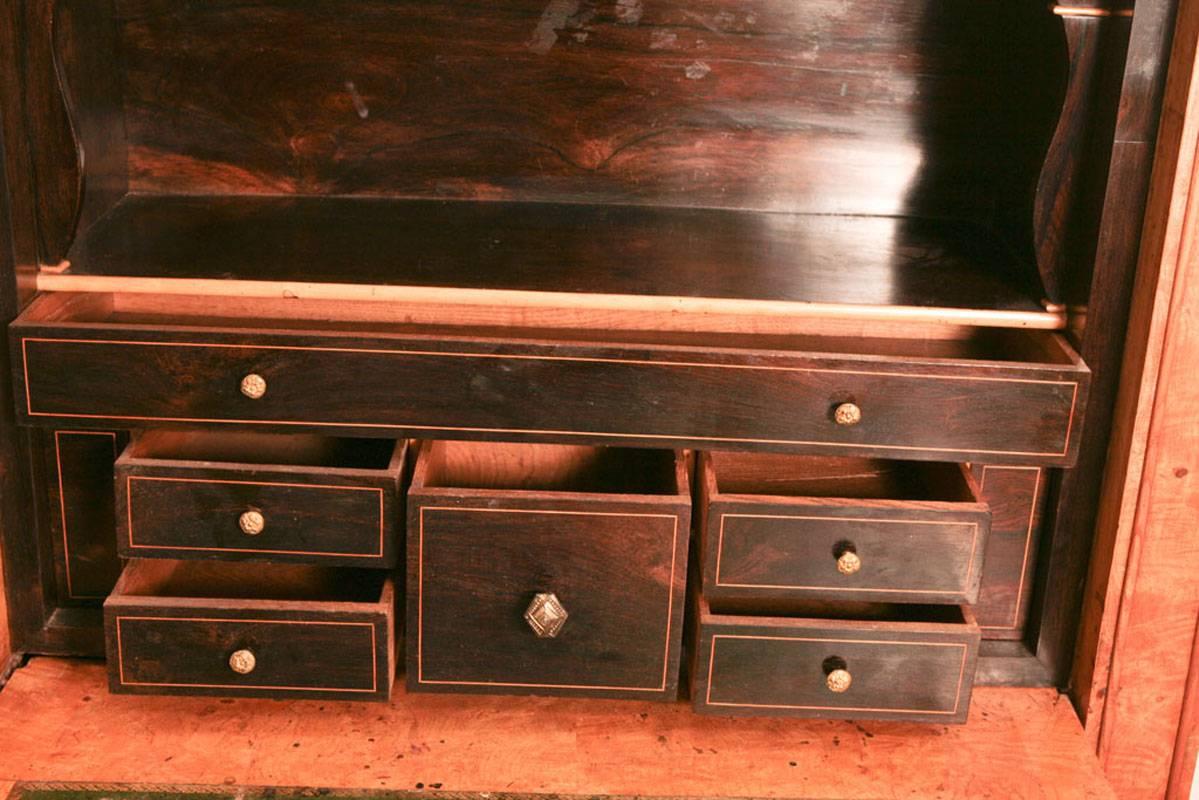 Segretaria a ribalta (secrétaire à abattant) in olmo Charles X con piano in marmo nero con inserti bianchi, anta a ribalta che rivela un tavolo da scrittura rivestito in pelle con interno ebanizzato composto da un ripiano e sei piccoli cassetti. Al