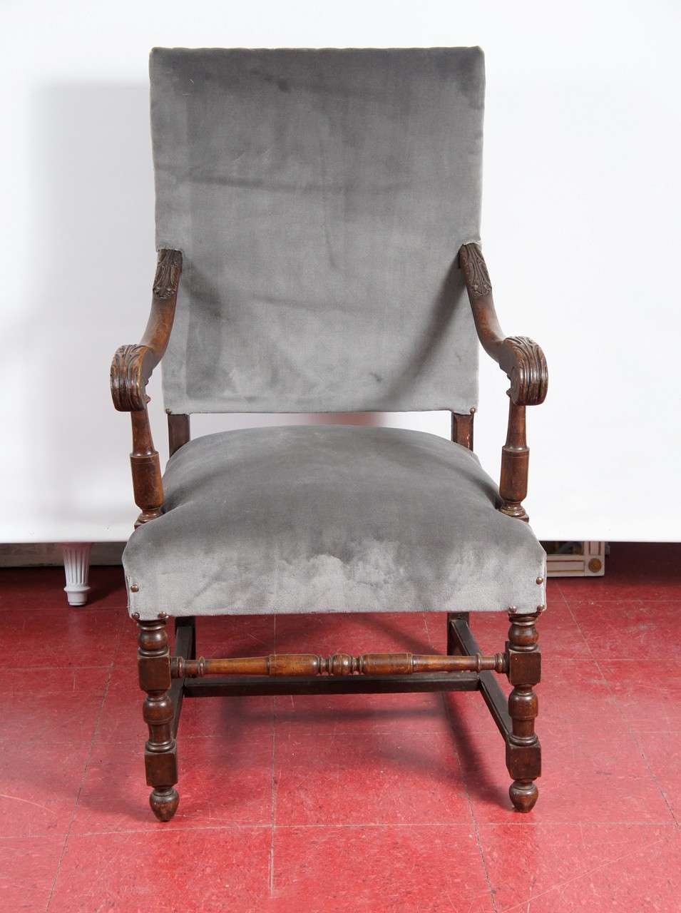 This French 17th century-style throne chair has solid oak framing and grey mohair upholstery and nailheads. The arms are hand-carved leaves and the legs are turned. Something for the head of the table or beside the fireplace? Comfort without taking