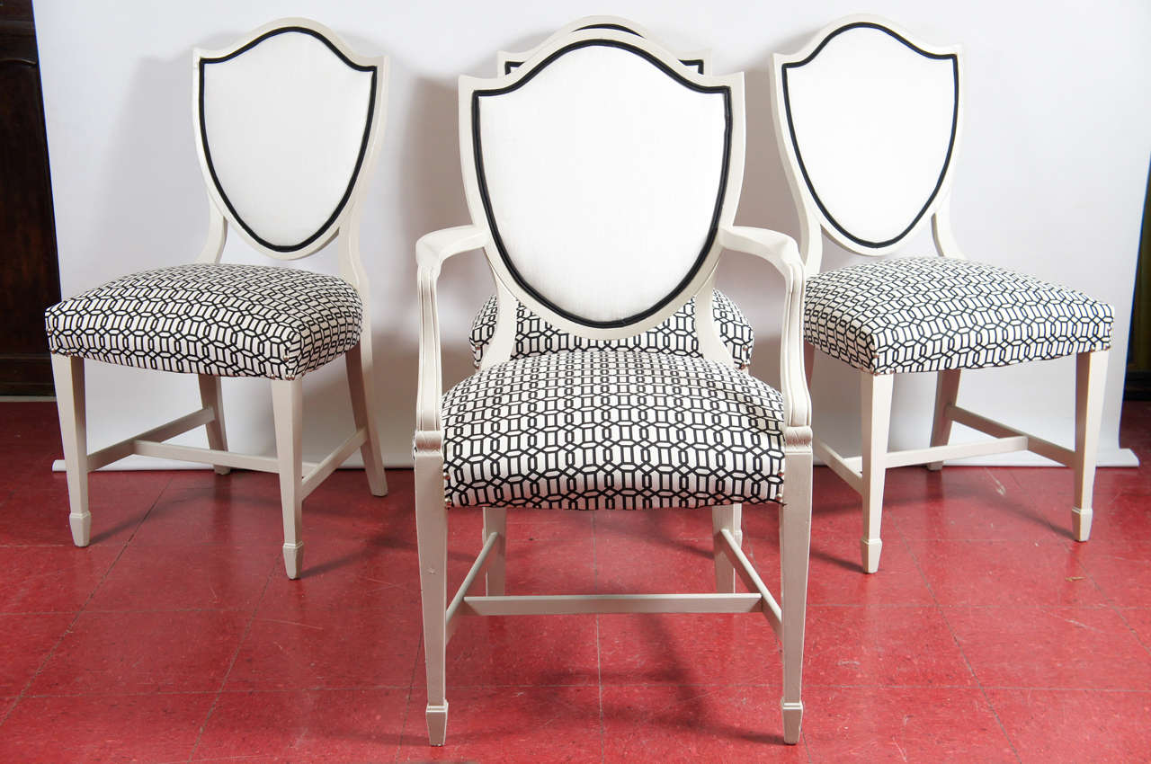 Esszimmerstühle im Adam-Stil aus der Mitte des 20. Jahrhunderts mit Schildrücken, einem Armlehnstuhl und drei Beistellstühlen, die weiß lackiert und mit schwarz-weiß gemustertem Stoff für die Sitze bezogen sind. Die Rückseiten sind aus weißem Stoff
