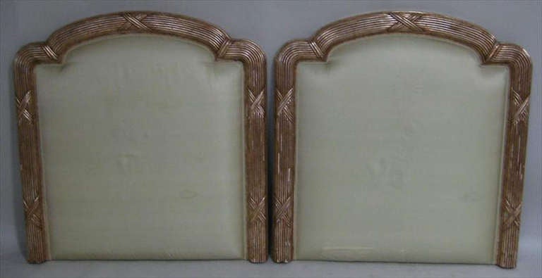 Pair of twin-sized upholstered and gilded headboards with molded and reeded frames. We can raised to height of the headboard to your specification.