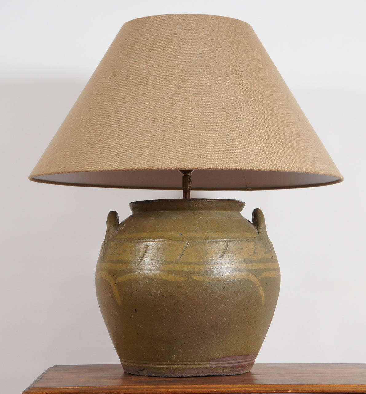 Large handsome two-tone green glazed Chinese water jar lamp comes with two handles, tan linen shade mounted European style and cord switch. The lamp is electrified for USA use. 

Measures: Over all height of lamp including shade is 26.5