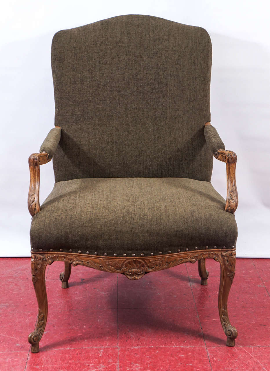 This newly restored antique French Provincial Louis XV fauteuil or armchair has an elegantly hand-carved walnut frame composed of leaves, shells and hearts. The upholstery is olive velvet. 
Search terms:  Throne chair. desk chair, office