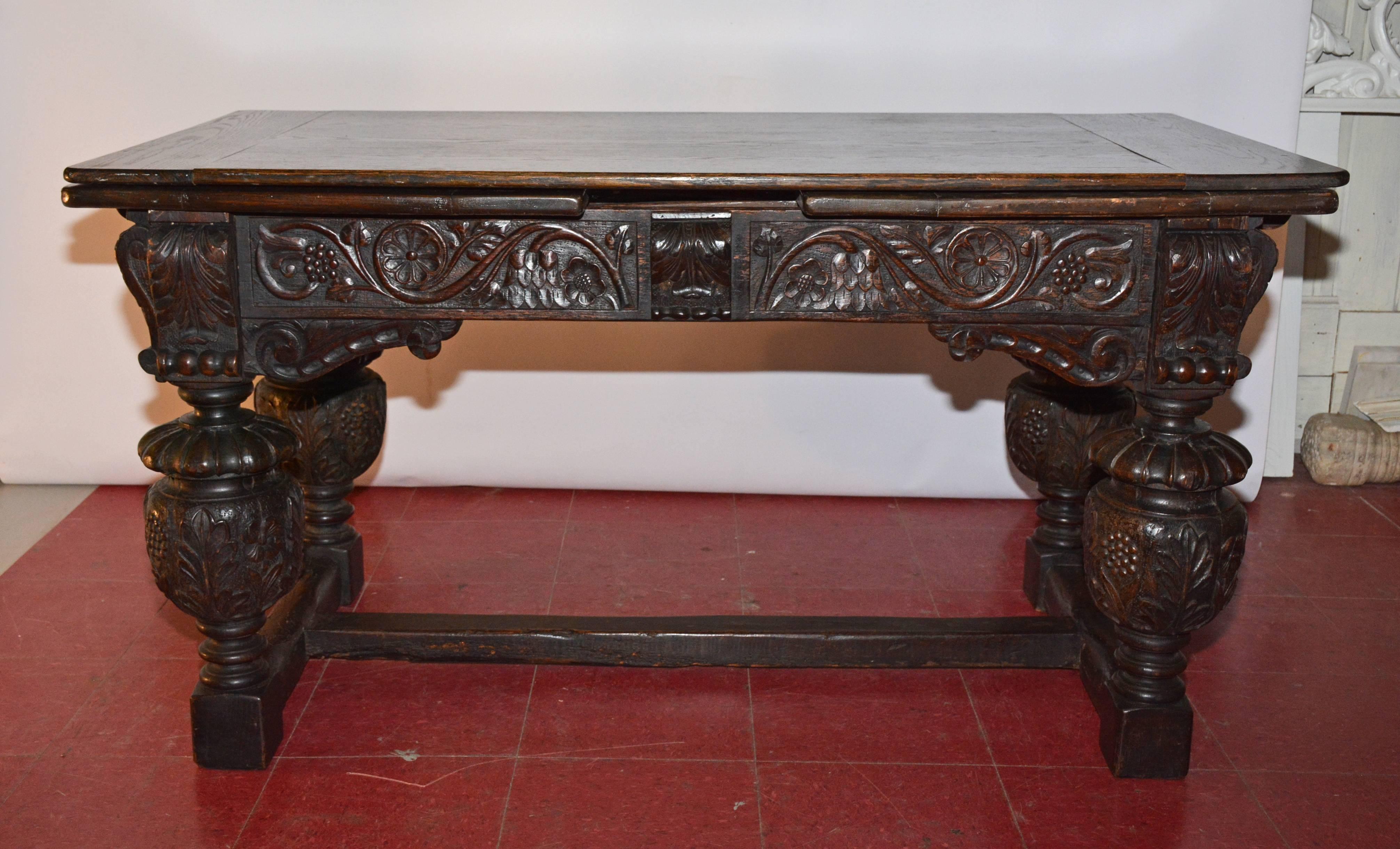 The Elizabethan/ Jacobean style dining table has beautifully hand-carved decorations of grapes, flowers, leaves and rosettes and aged patina.  The table extends to double its closed size which is 57
