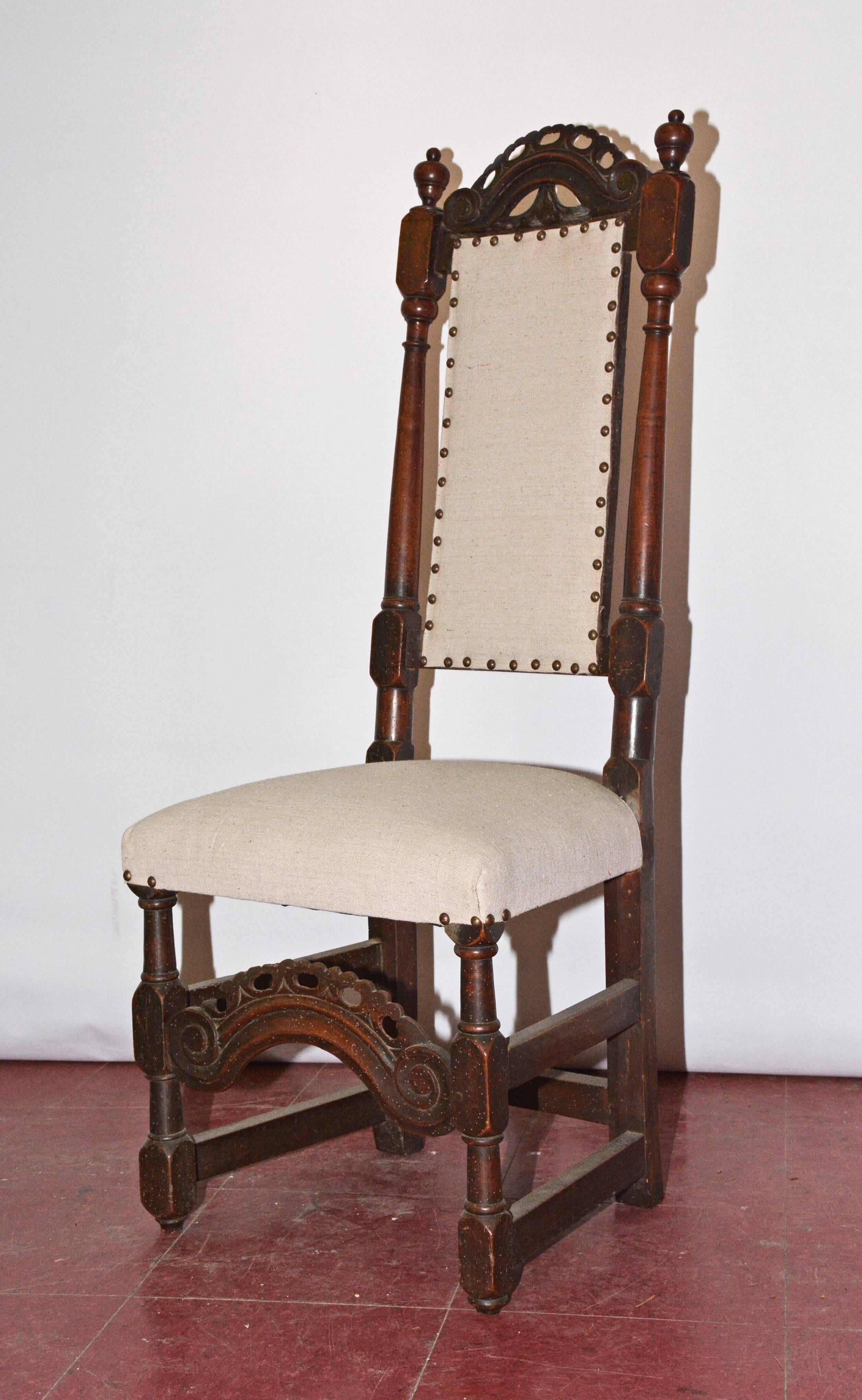 Decorated with elaborately hand-carved back and stretcher, the Jacobean chair is newly upholstered in beige linen surrounded by iron colored nails.
 