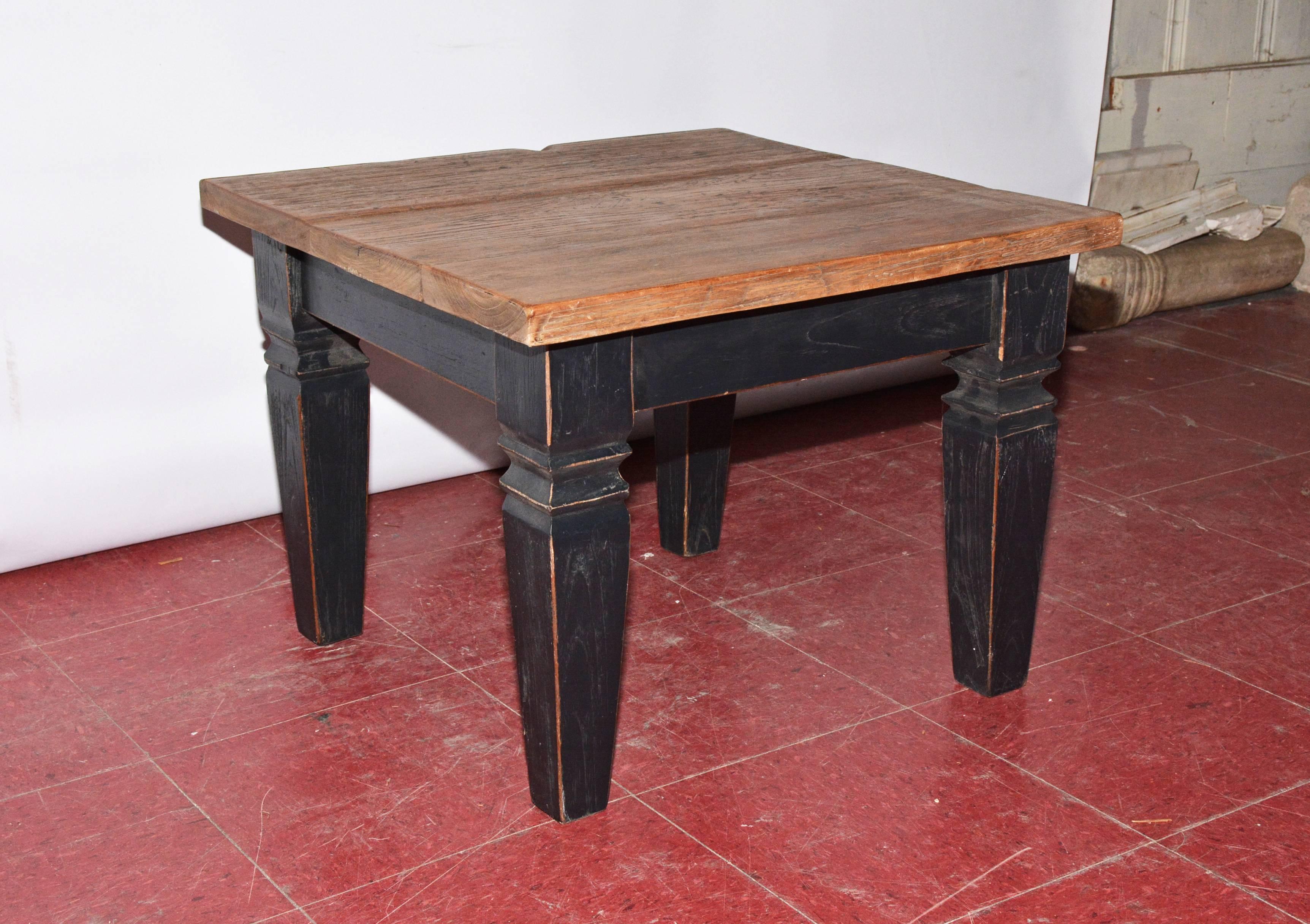 The vintage piece of furniture could be used as an end table or a coffee table. The black stained legs with brown highlighted edges are bolted to the aprons. The brown top has prominent graining. The weight is substantial. No number.