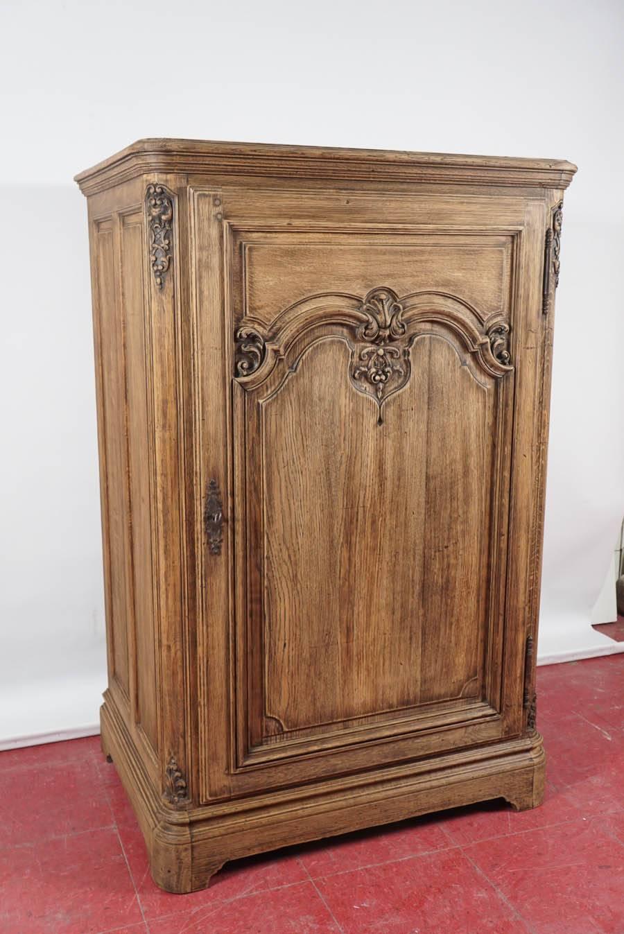 A large version of a French confiture, hand-carved with Rococo design on the front and double paneling on the sides. Hinged door with lock and key and two shelves inside. Possible one-of-a-kind use as a bar or for linens.

Search terms:  single door