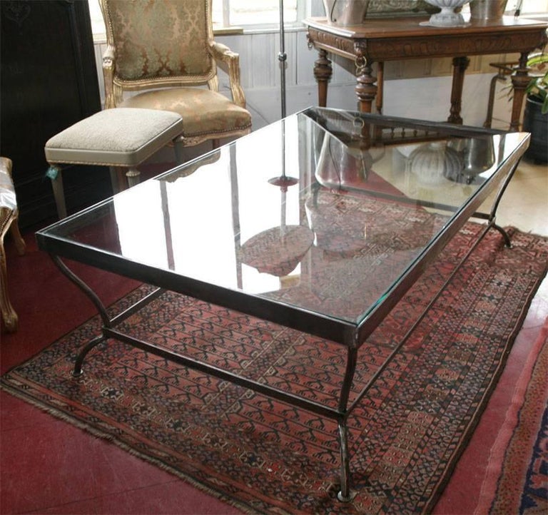Custom made to size, glass and polished iron coffee table. Can be made to customer specification. Similar design available in dining table or side table versions. 
Table can support stone, wood or glass.  Other finishes available.  Lead time 9 to 10