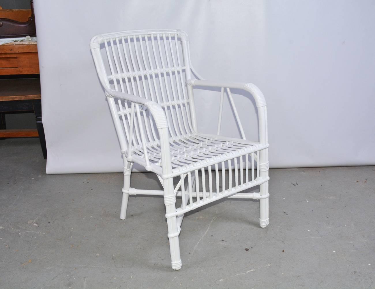 The vintage porch armchair is made of rattan and is newly painted glossy white. The legs have criss-cross stretchers and a rattan apron between the front legs. The construction is solid. Ready to include the cushions of your choice.

Arm: 26