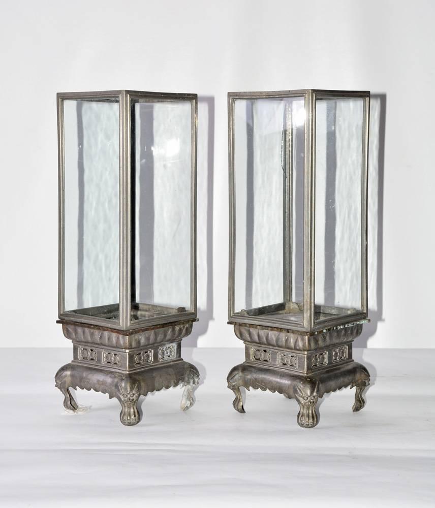 The pair of vintage Chinese footed lanterns are made of lead with glass panelled enclosures. The paw feet are topped with dragon heads.
   