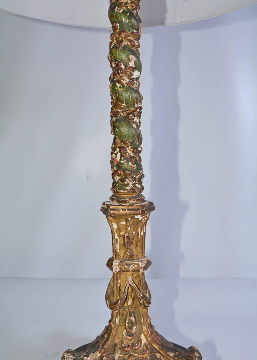 The Renaissance Italian lamp is composed of an antique three-footed barley-twist candlestick electrically wired for US use with three chain switch lights. The green-with-giltwood candlestick sits on a round green wood platform. The white silk shade