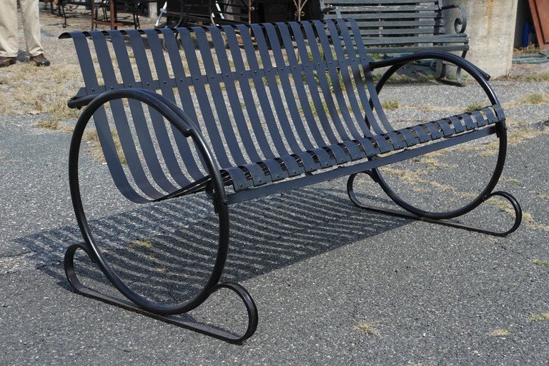 Stylish deco style metal outdoor or porch bench in steel includes seating for three attached to circular arms and feet.  Newly sandblasted and primed in black.

Arm height: 25 