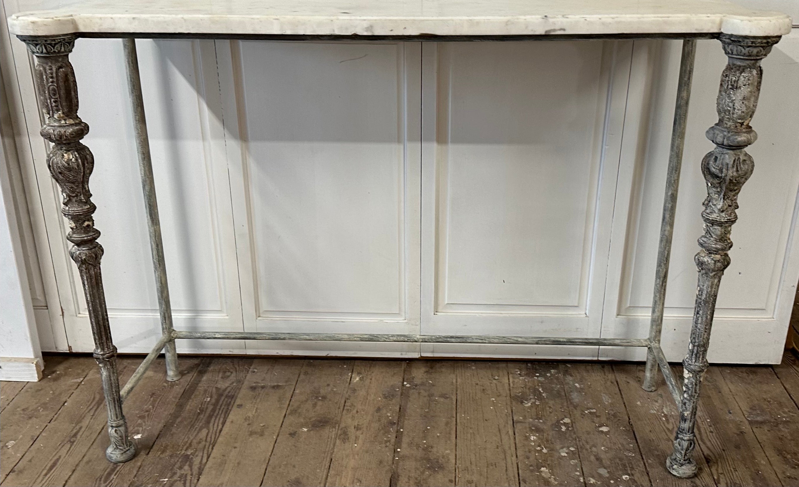 Antique French Louis XVI style console table made with two Louis XVI style legs in the front and two round iron legs in the back, tied together on the side and back with straight stretchers.
The top is an antique French white marble top with two