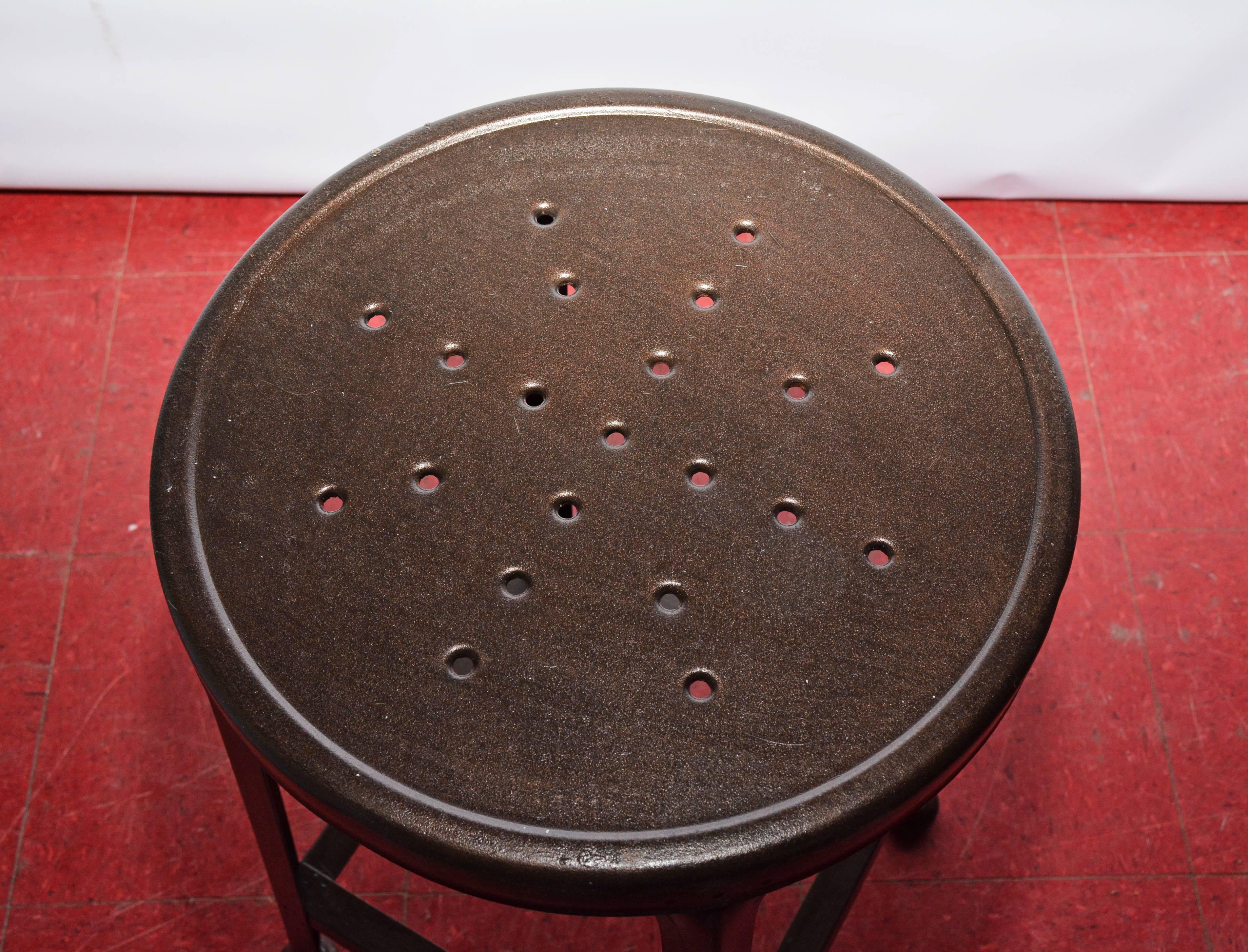 The iron stool has a perforated seat and legs with stretchers and padded fe.

Measures: Seat diameter 14.50.