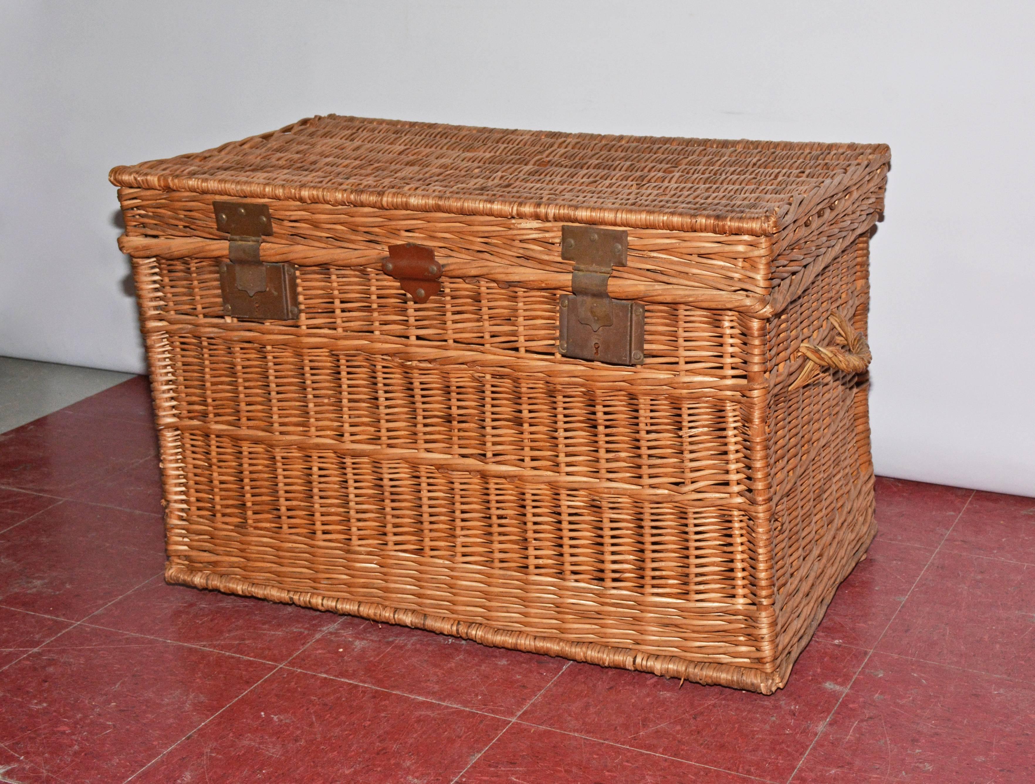 A large French woven willow wicker trunk has a lid, two metal locks and two handles. Can be used as a blanket chest.
  