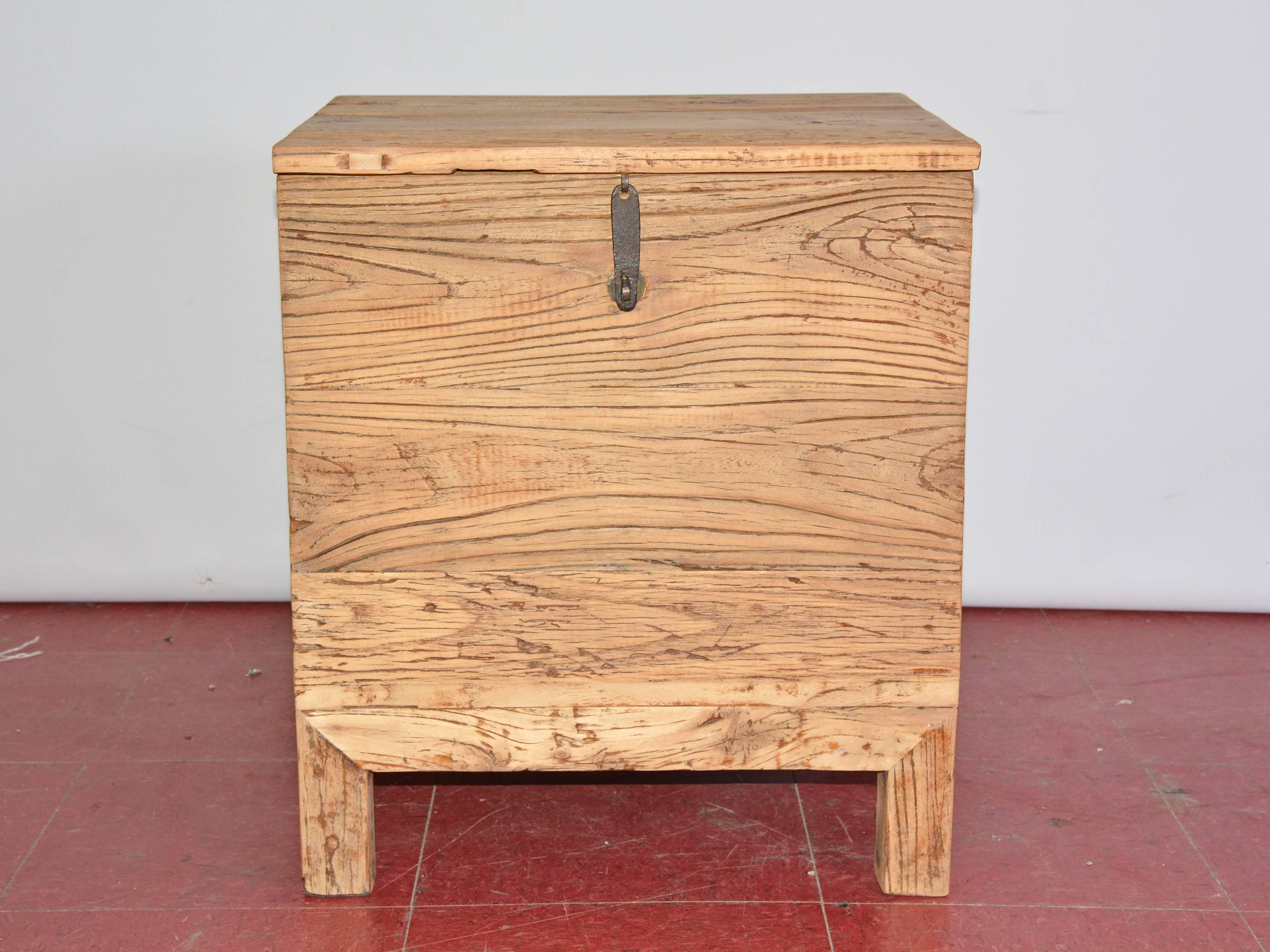 The Chinese lidded storage box works well as a side or night table having full storage capacity. Approximately two-thirds of the depth of the top is a removable lid that has an iron latch and loop for a padlock. Two protruding arms at the back of