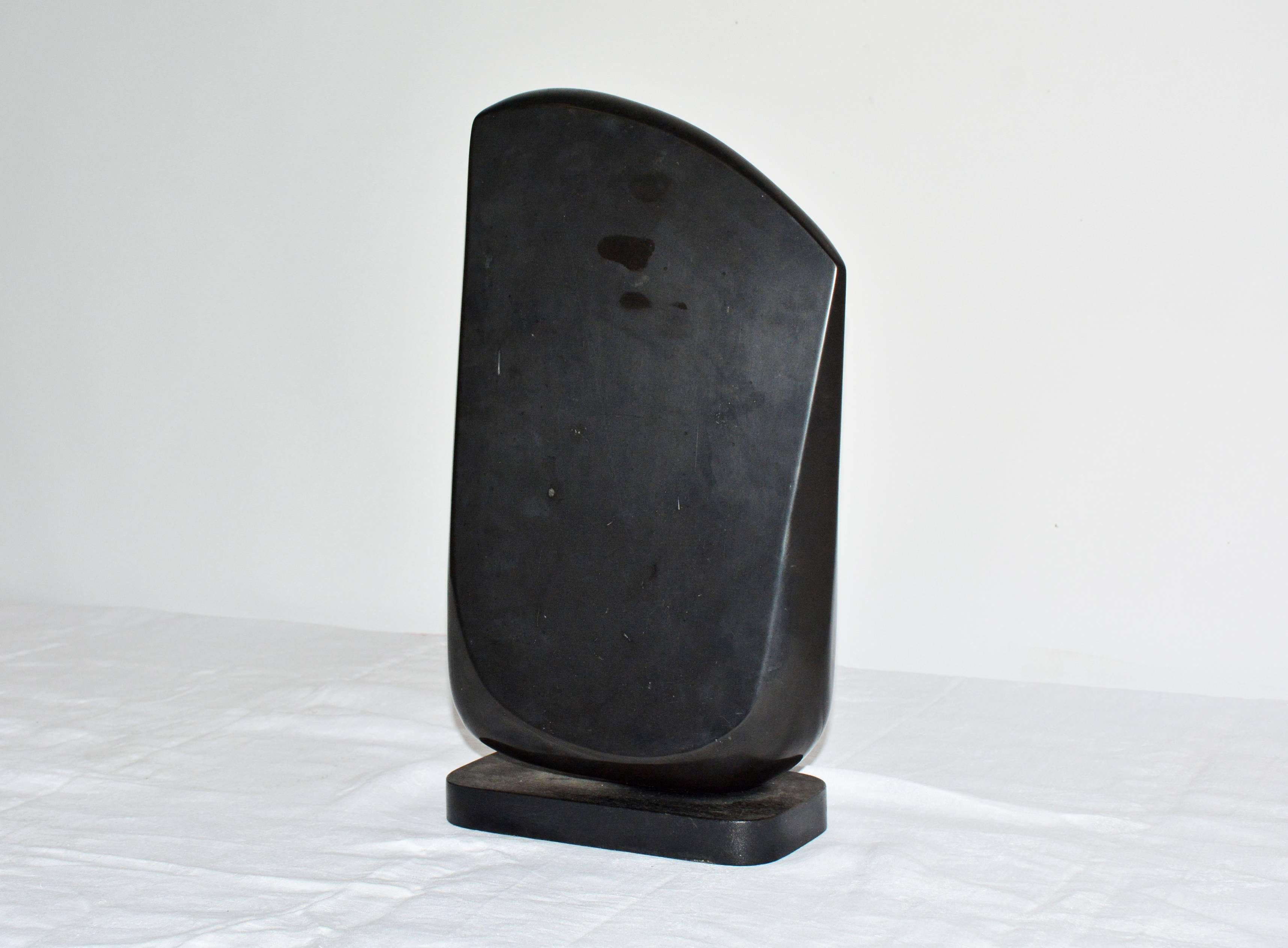 The contemporary black marble sculpture sits on a black wood base lined underneath with green felt. Award winning sculptor, Jean Downey (1931-2009) born in Canada, studied art in Illinois, New York and Connecticut. Her work is included in private