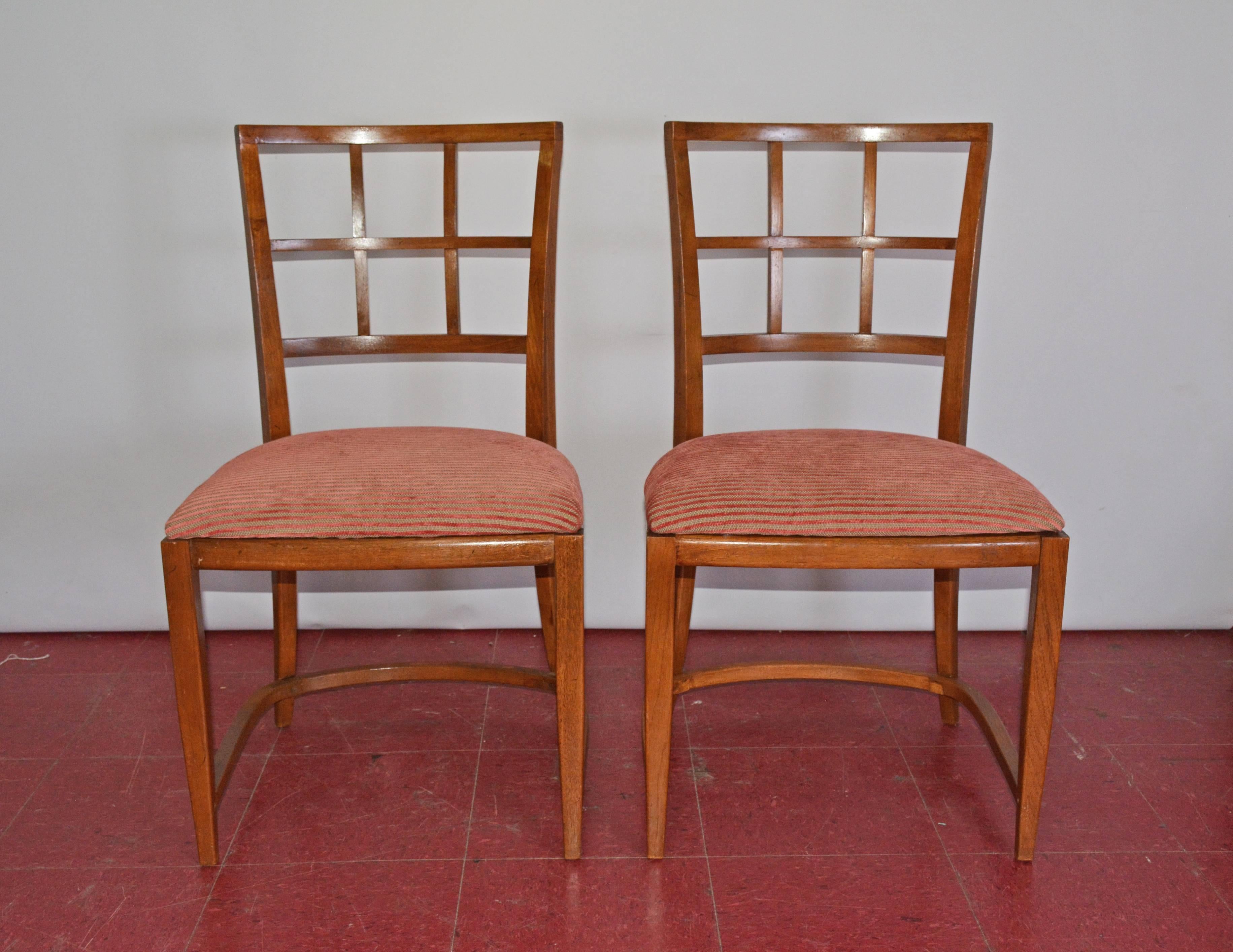 The pair of Art Deco dining chairs have rounded leg framing and backs. The seats are newly upholstered in ribbed red and tan striping. Great as office chairs, desk chairs or side chairs. Two additional matching arm chairs available.