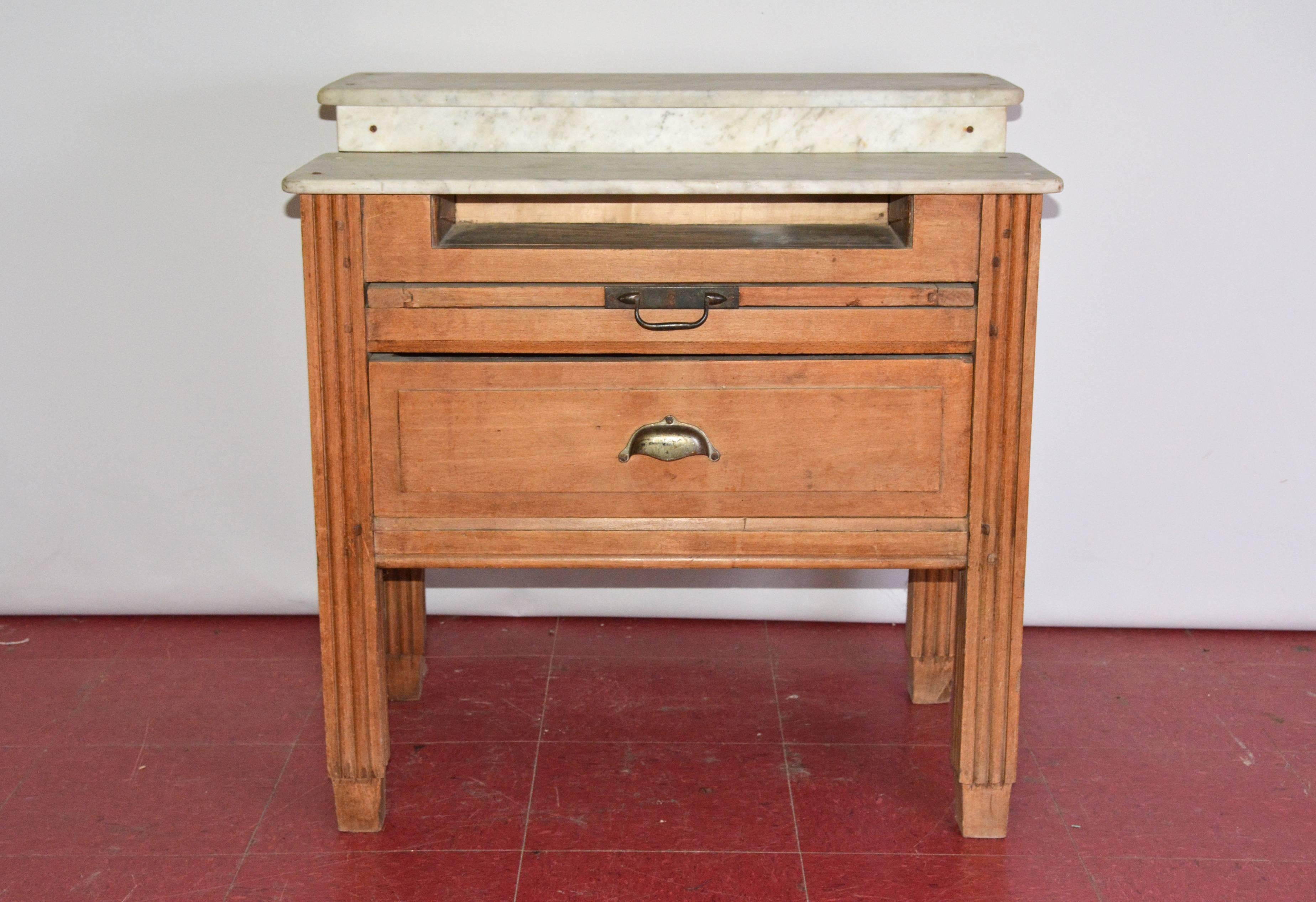 Wonderful antique French baker's wrapping table has a two-level marble top, a shelf underneath the top, a pull-out cutting board and a drawer. Marble top has great antiqued patina giving this table lots of character. The pulls are iron. The square