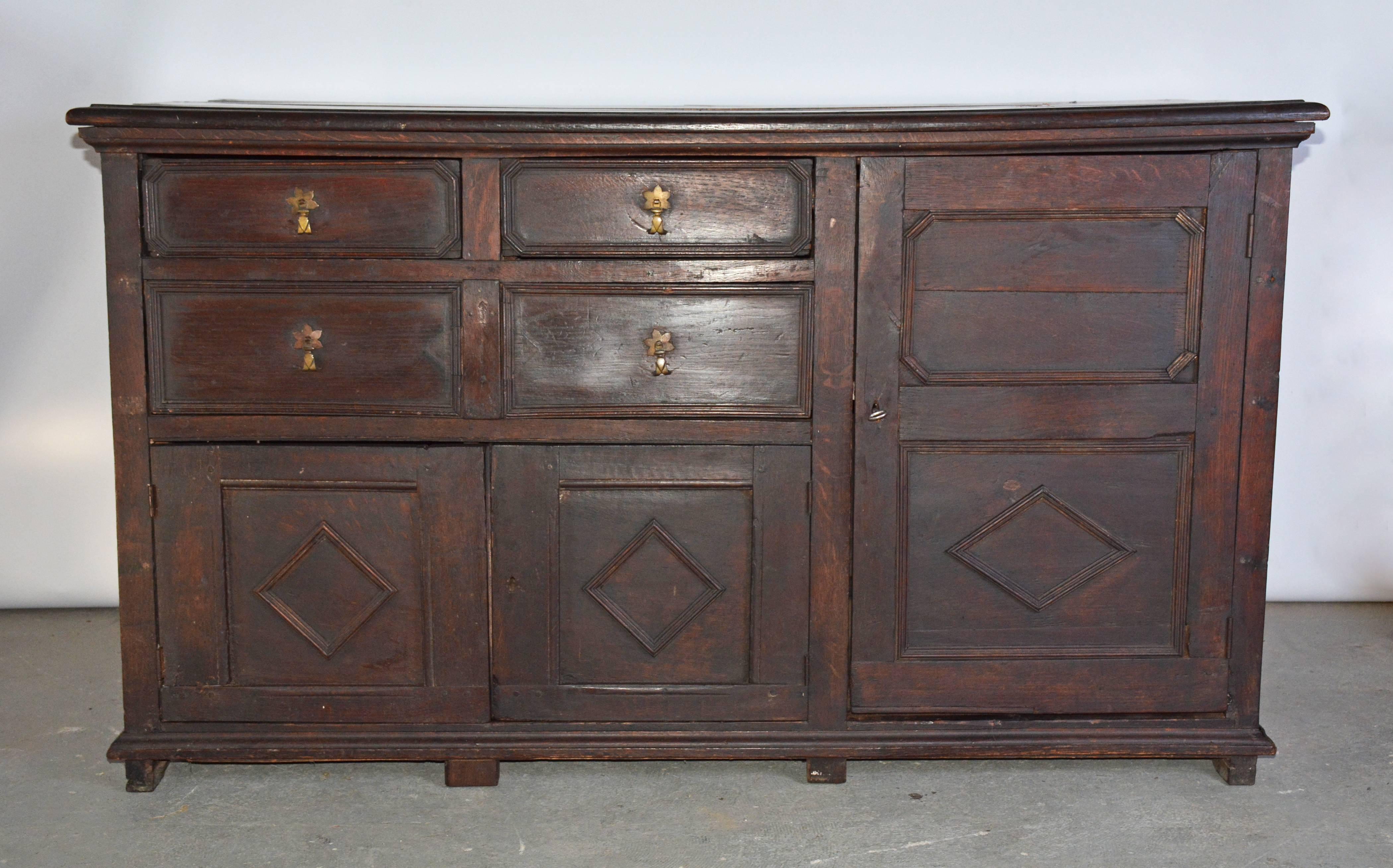 18th century William & Mary oak sideboard with four drawers, two smaller cabinet beneath and a larger on the side. The chest displays all the features associated with the era the geometric design on the drawer and cabinet fronts.
Search terms: 