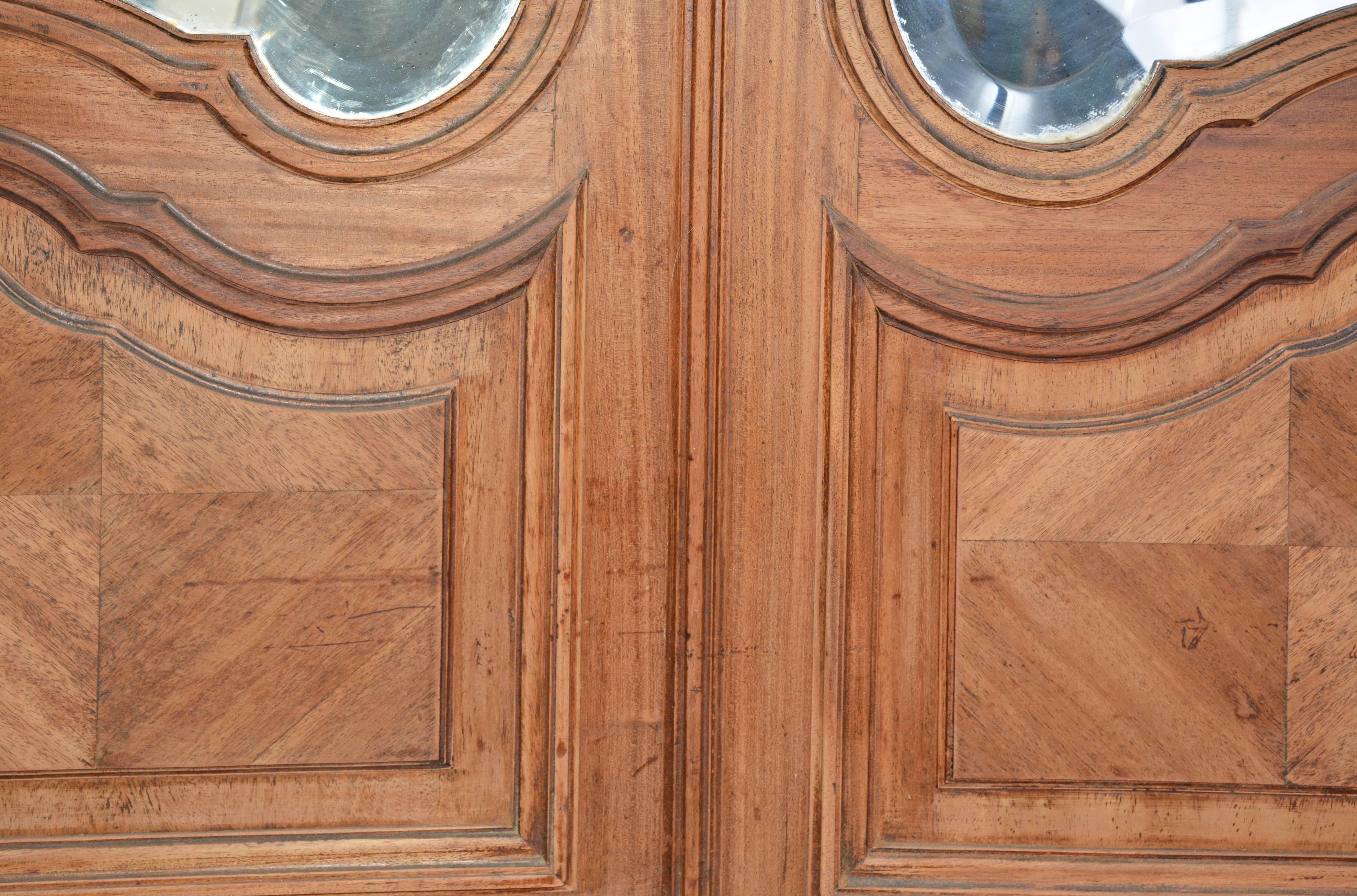 Das Paar französischer Rokoko-Spiegeltüren aus dem 19. Jahrhundert kann als Garderoben- oder Schranktür verwendet werden. Wunderschöne Vertäfelungen, Rokoko-Schlossbeschläge und abgeschrägte Spiegel sind Teil des Designs.