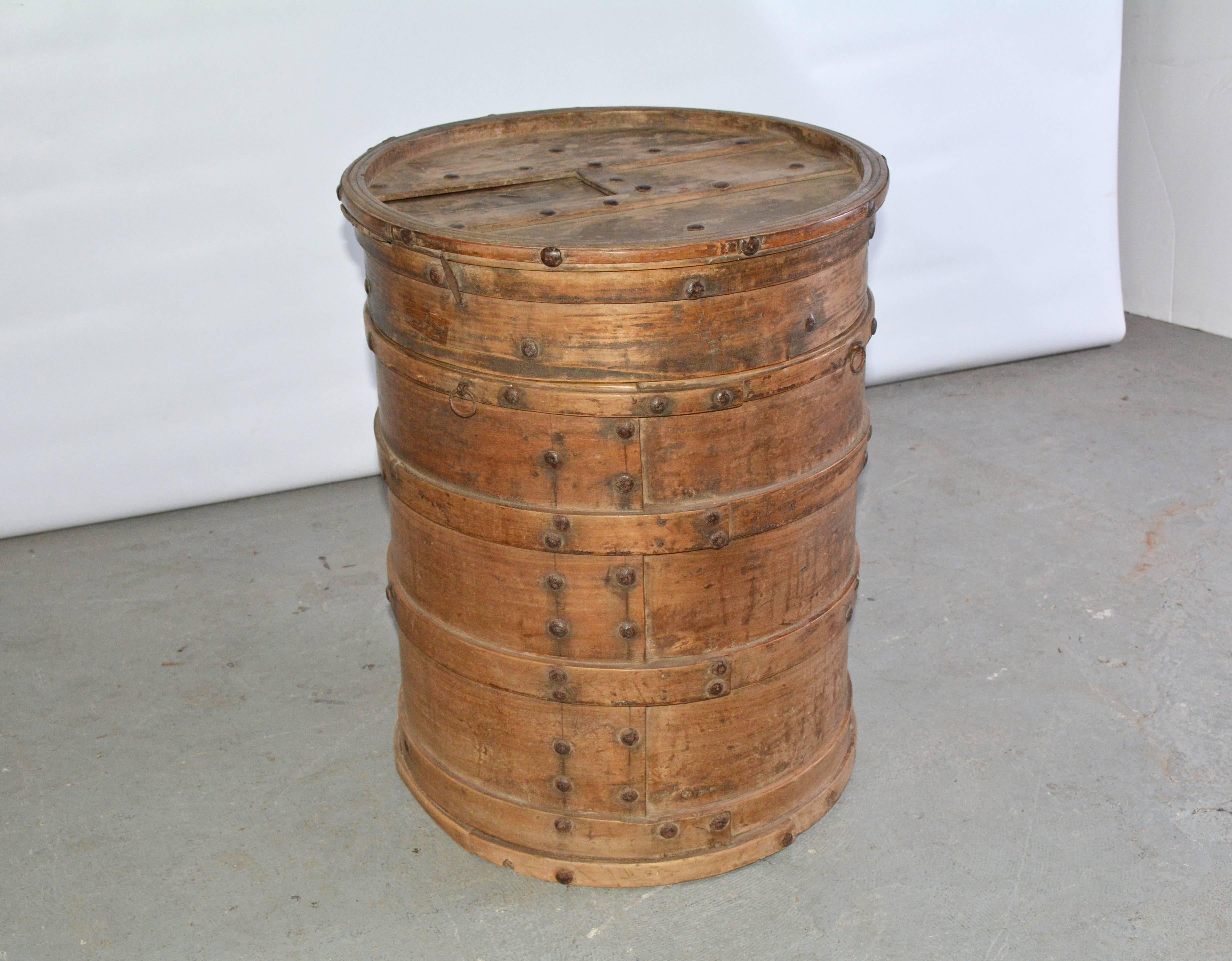 The antique round Asian storage container is composed of strips of bentwood that have been pinned together. The matching lid with a bottom of its own has a sliding panel that reveals a hole. Can be used as side table or table base.