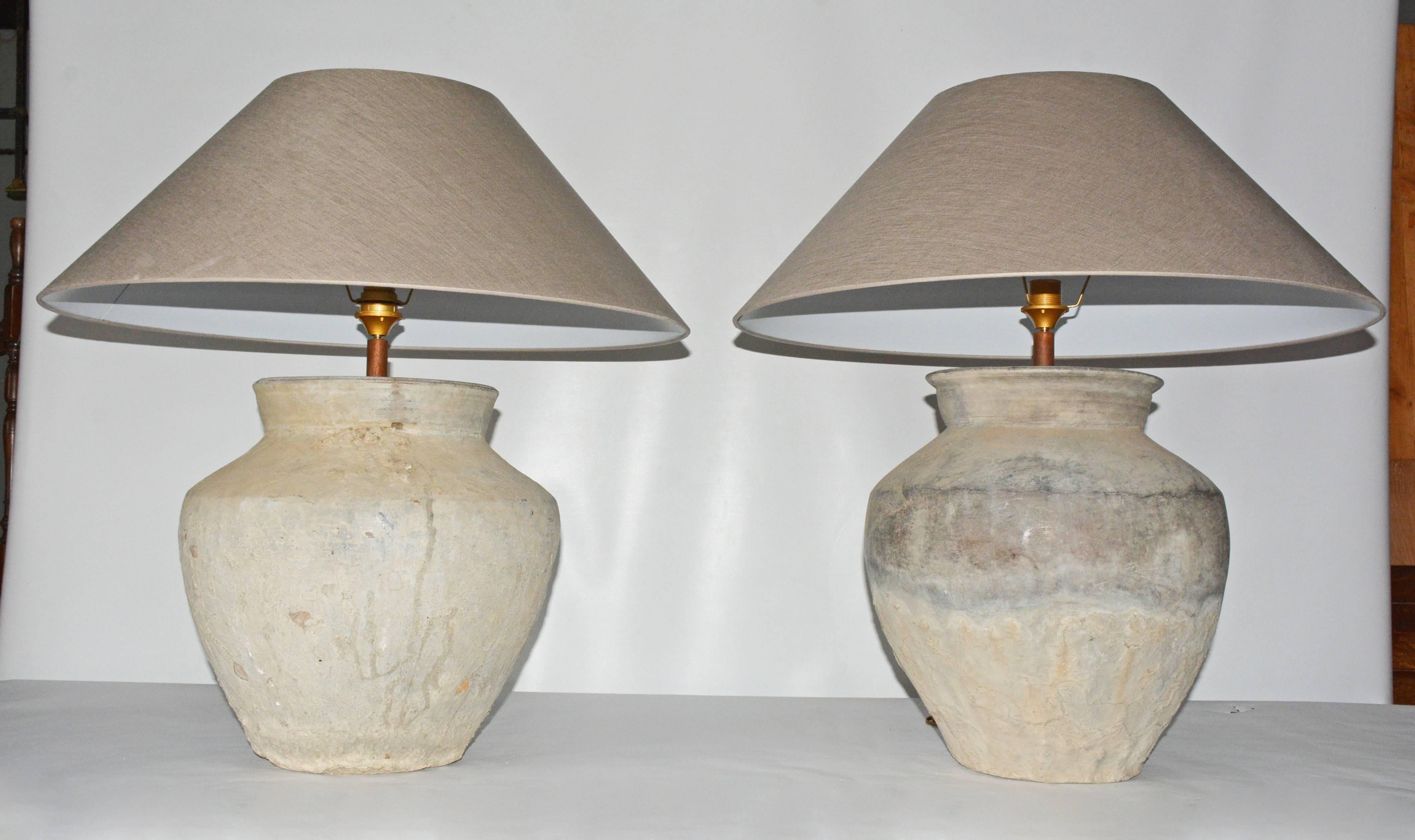 Two similar early large rustic Chinese unglazed terracotta storage jars that has been mounted as a table lamps. The vase has beautiful aged patina from being buried perhaps for centuries.
Handmade taupe color Belgium linen coolie shape