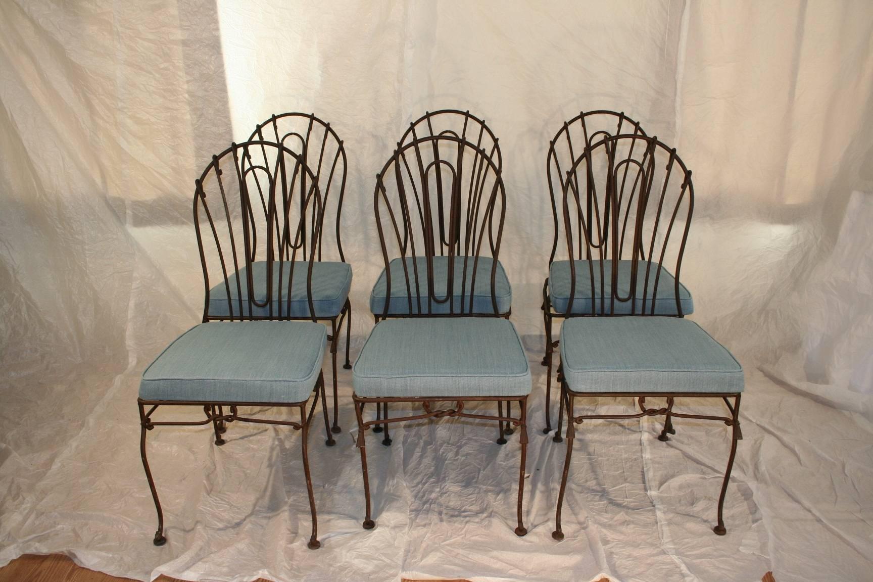 Set of eight wrought iron garden dining chairs with sturdy and removable cushions with newly upholstered pale blue fabric.
