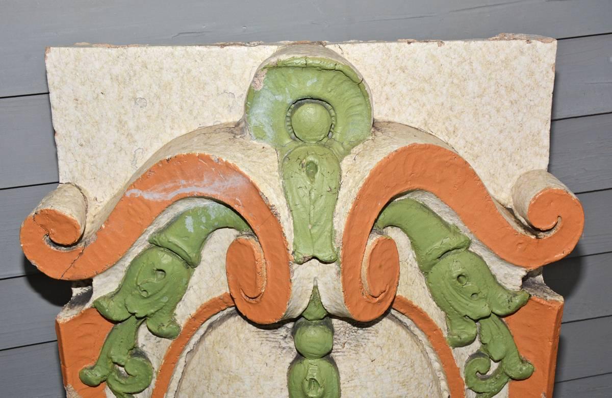 The antique architectural salvaged building element with cartouche design is molded cement and glazed and painted orange and green. The back is hollow.

Widest part: 27