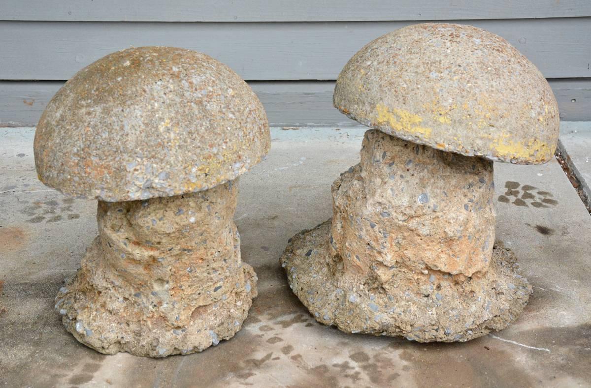 Charming pair of antique toad stool garden ornaments have separate tops and bottoms. They are made of molded cement. The tops have iron bars underneath that fit into holes of the bottoms.

The dimensions are for the larger mushroom.