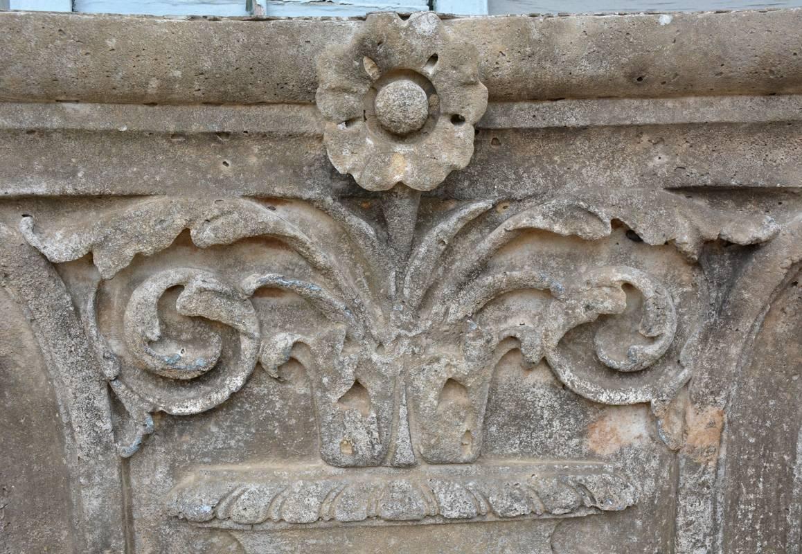 The antique architectural stone pilaster capital sits on a base. The framed design includes an urn and a spray of vines and leaves topped by a rosette.

Top measurements: 37.75