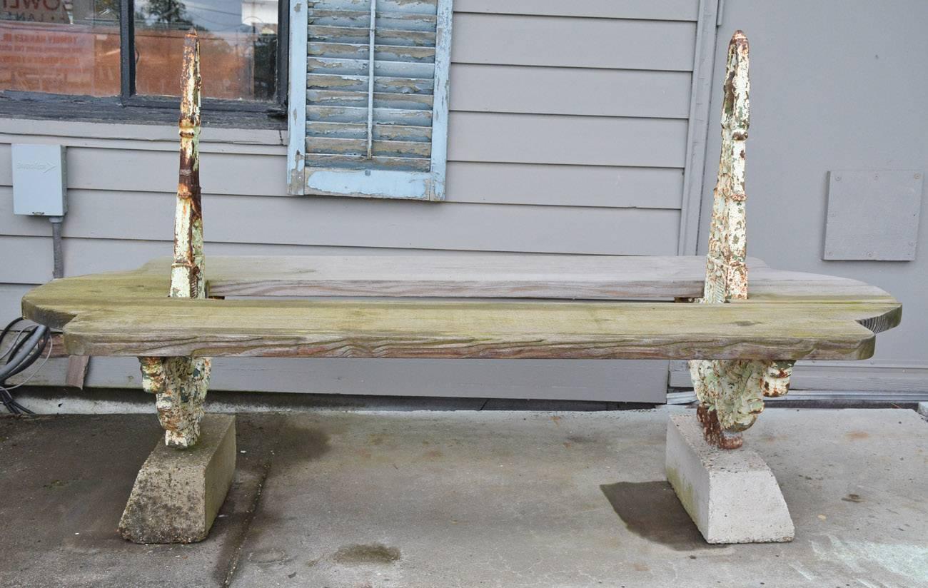 Rare antique French garden bench is made of three components: Wood planking for double seating, front and back, as well as sides, decorative cast iron braces and stone block bases. The unit could also be used for holding potted plants. New wood can