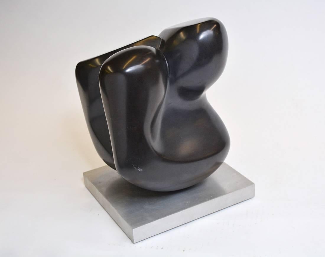The modern black marble sculpture is hand-carved by Jean Downey and stands on an aluminum platform.